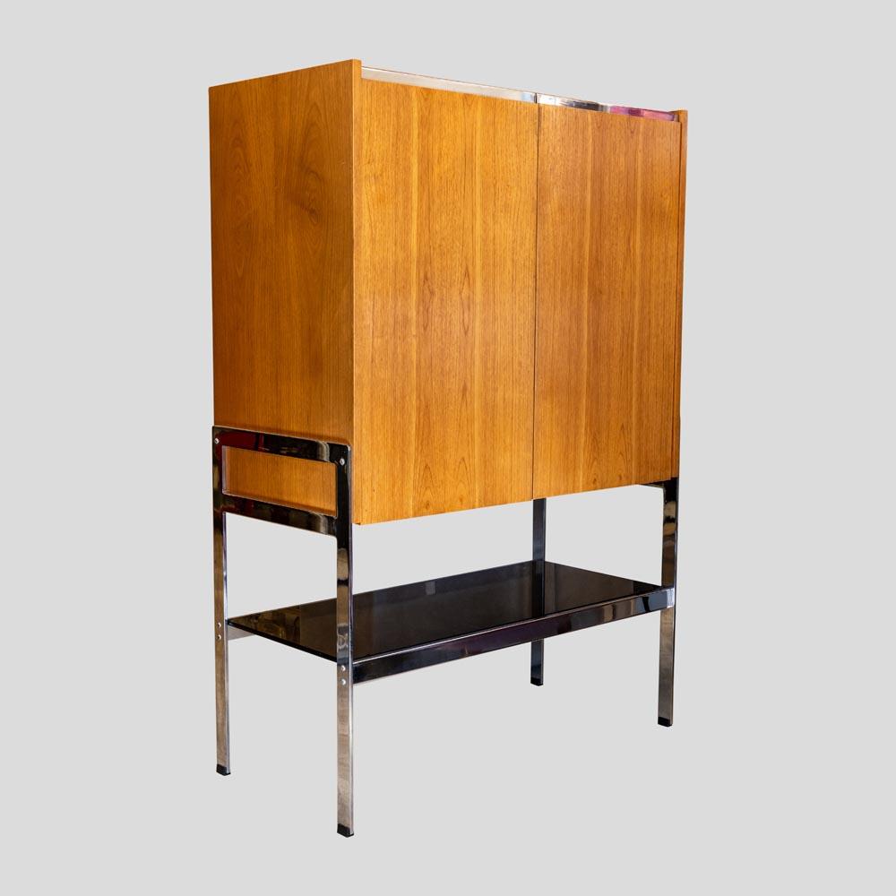 Stunning vintage Mid Century Modern Design Cocktail cabinet. Teak wood and Chrome Metal stand structure, clear glass internal shelves and brownish smoked glass external shelve. English Design by Richard Young for Merrow Associates in the 1970S
This