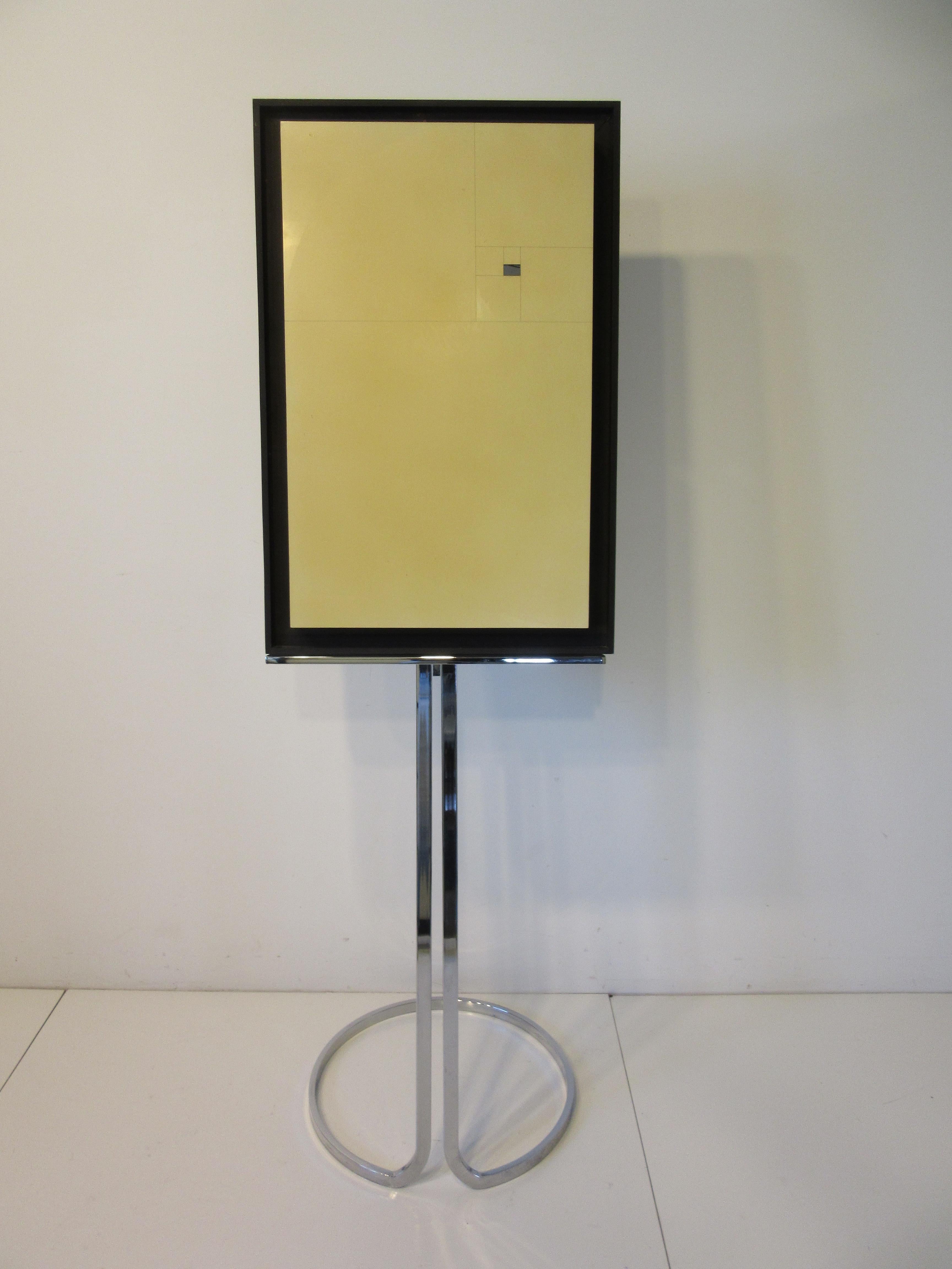 A nicely constructed adjustable chromed metal framed 1970's mid century art display easel with upper and lower thumb screw locking adjusters. Very stable with it's round base and slotted adjustment design the holding platform bar at 20.75
