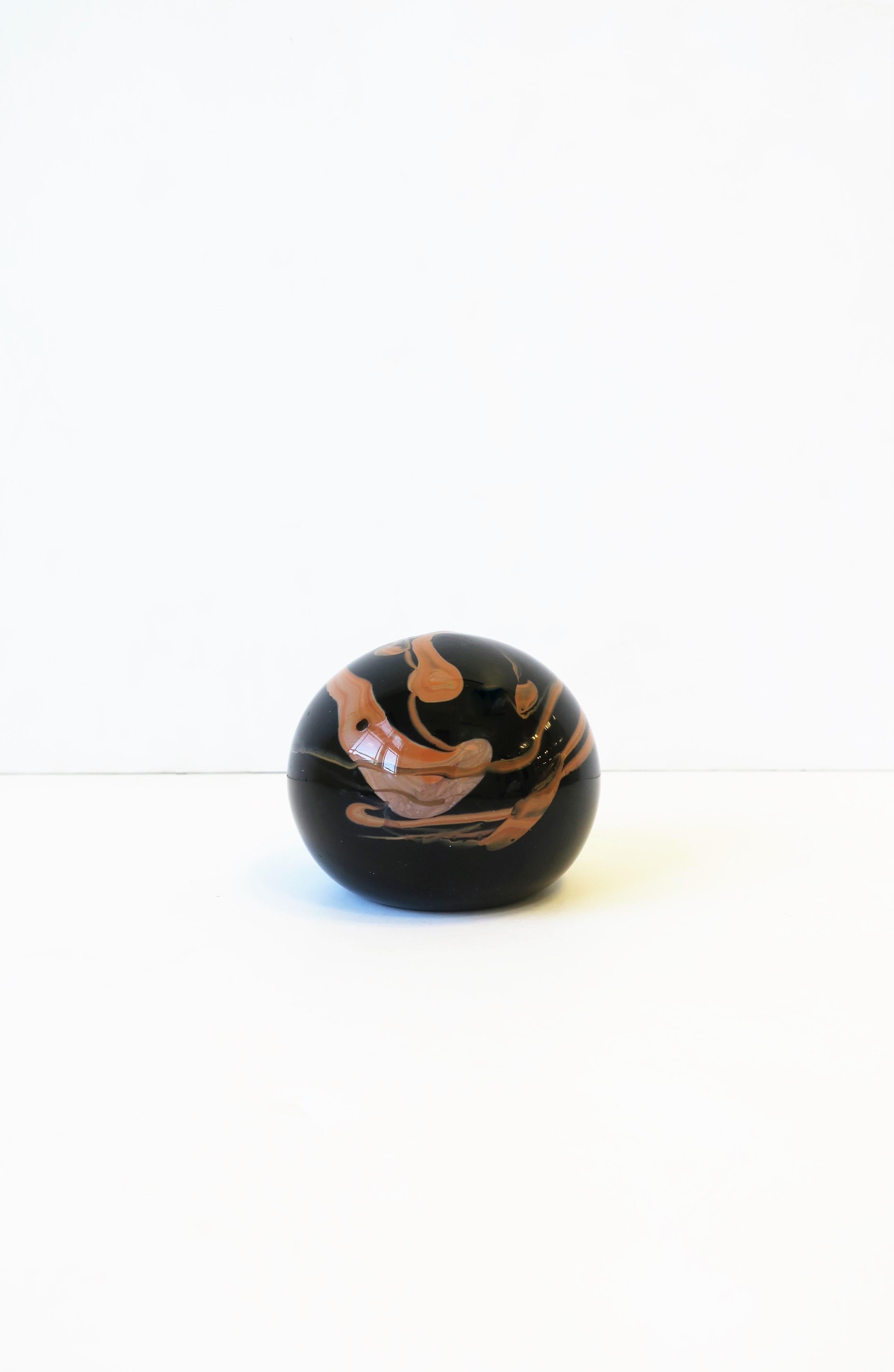A beautiful Modern/Postmodern black and neutral flesh-tone art glass decorative object or paperweight with an organic modern design, circa 1970s. This handmade art glass coloring and design resembles that of Italian Portoro marble. A great piece for