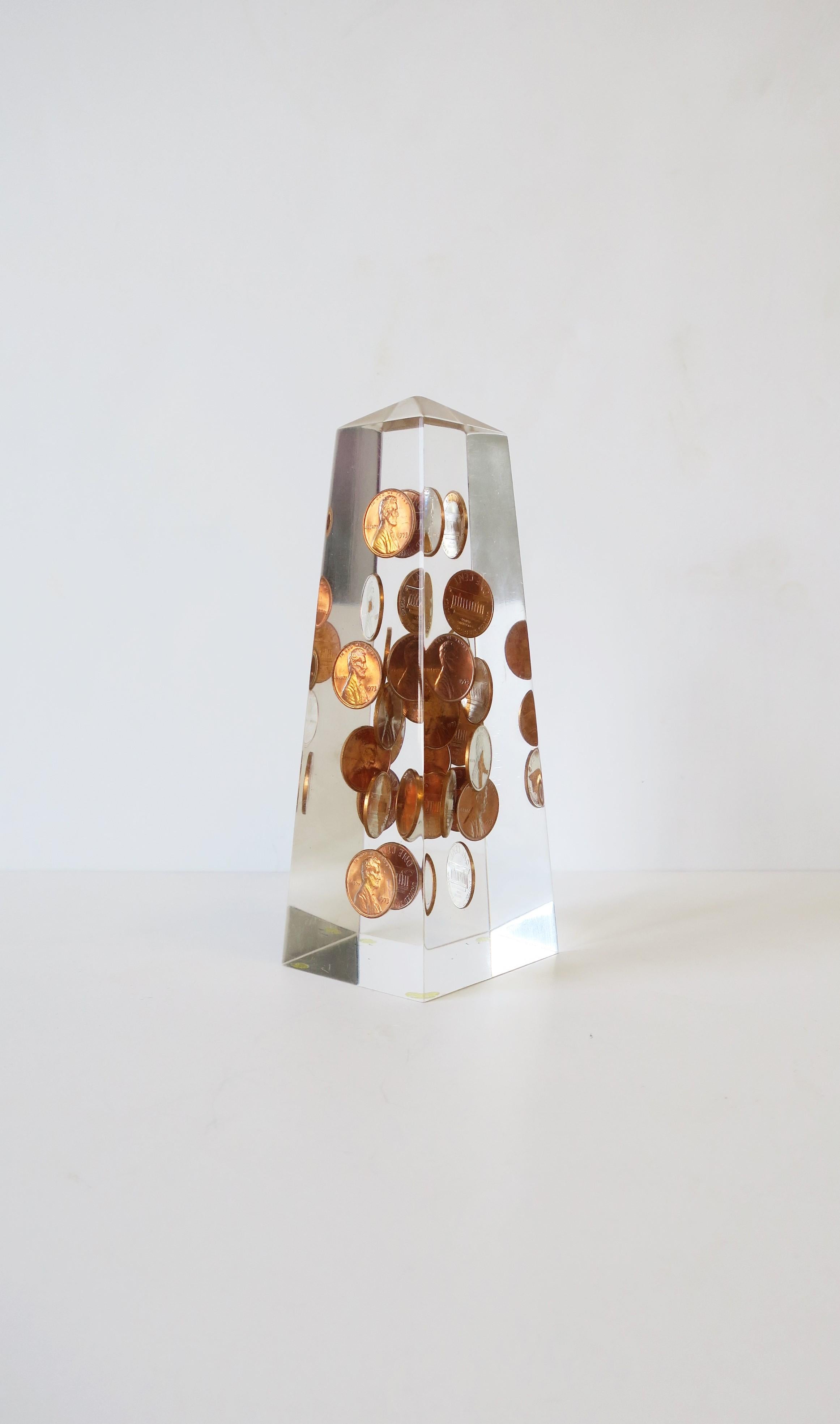 A great 1970s modern or Postmodern period Lucite and U.S. coppery penny decorated obelisk. All copper pennies encased are dated 1973. Obelisk measures: 2.13