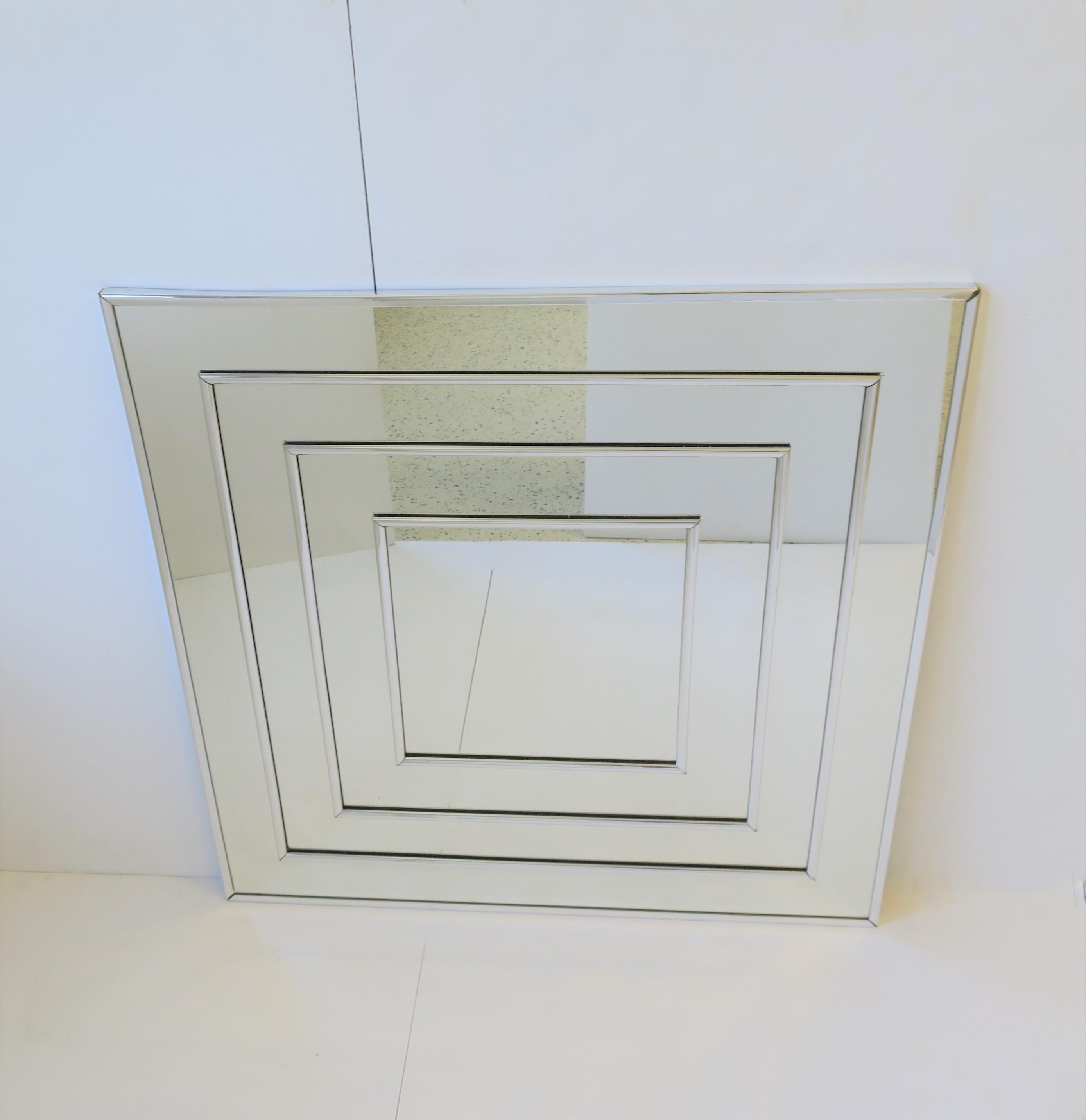A vintage '70s modern mirror with chrome detail and frame, circa 1970s, USA. Mirror is prepared to hang across (square) or at its corner (diamond shape) as show in image #7 and 8. Mirror measures: 30