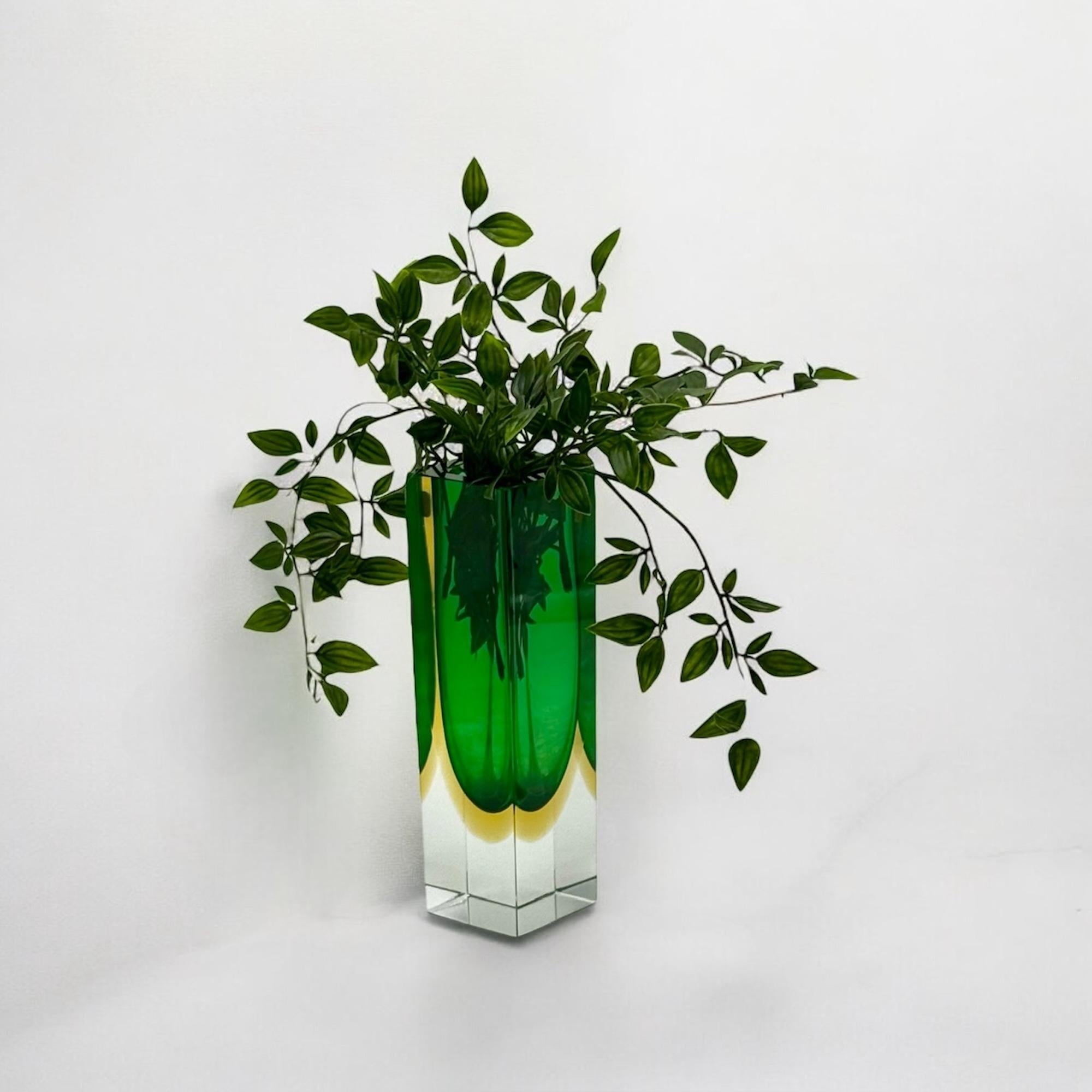 This 1970s Murano Sommerso vase is a remarkable representation of Murano’s glassmaking heritage. Handcrafted using the Sommerso technique, the vase features a seamless gradient of green, yellow, and clear glass, creating an exquisite play of color