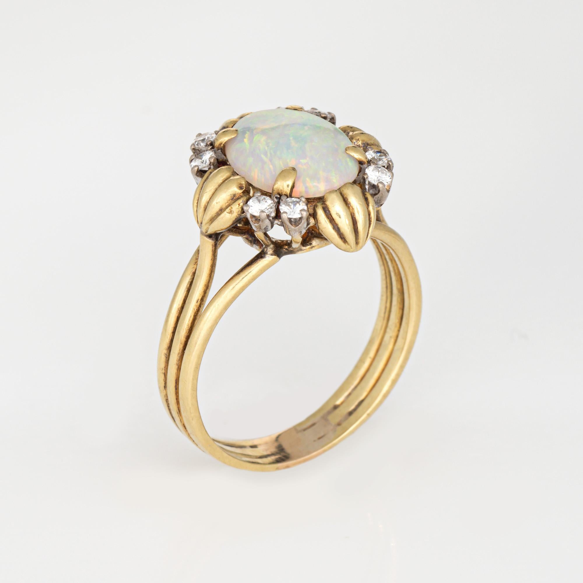 Bague élégante en opale naturelle et diamant (circa 1970) réalisée en or jaune 18k. 

L'opale naturelle mesure 10 mm x 7,5 mm. Huit diamants totalisent un poids estimé à 0,08 carat (couleur estimée I-J et pureté estimée SI1-I1). L'opale est en très