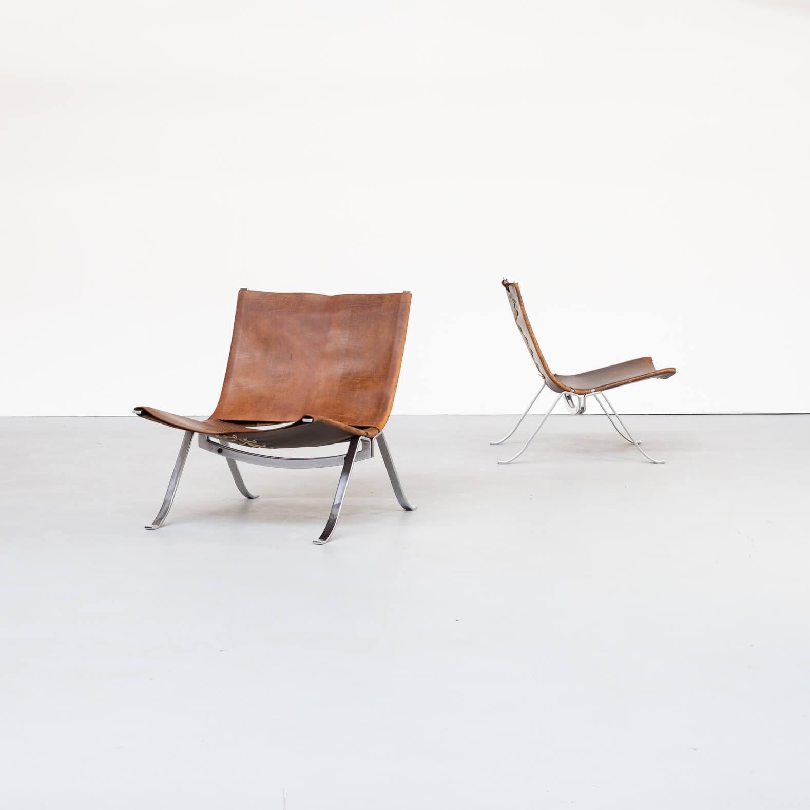 A pair of lounge chairs by Fabricius. The very well formed metal frames hold a sturdy brown leather upholstery, tied together with a rope. These very desirable and extremely rare and comfortable design chairs can be placed in the same range of