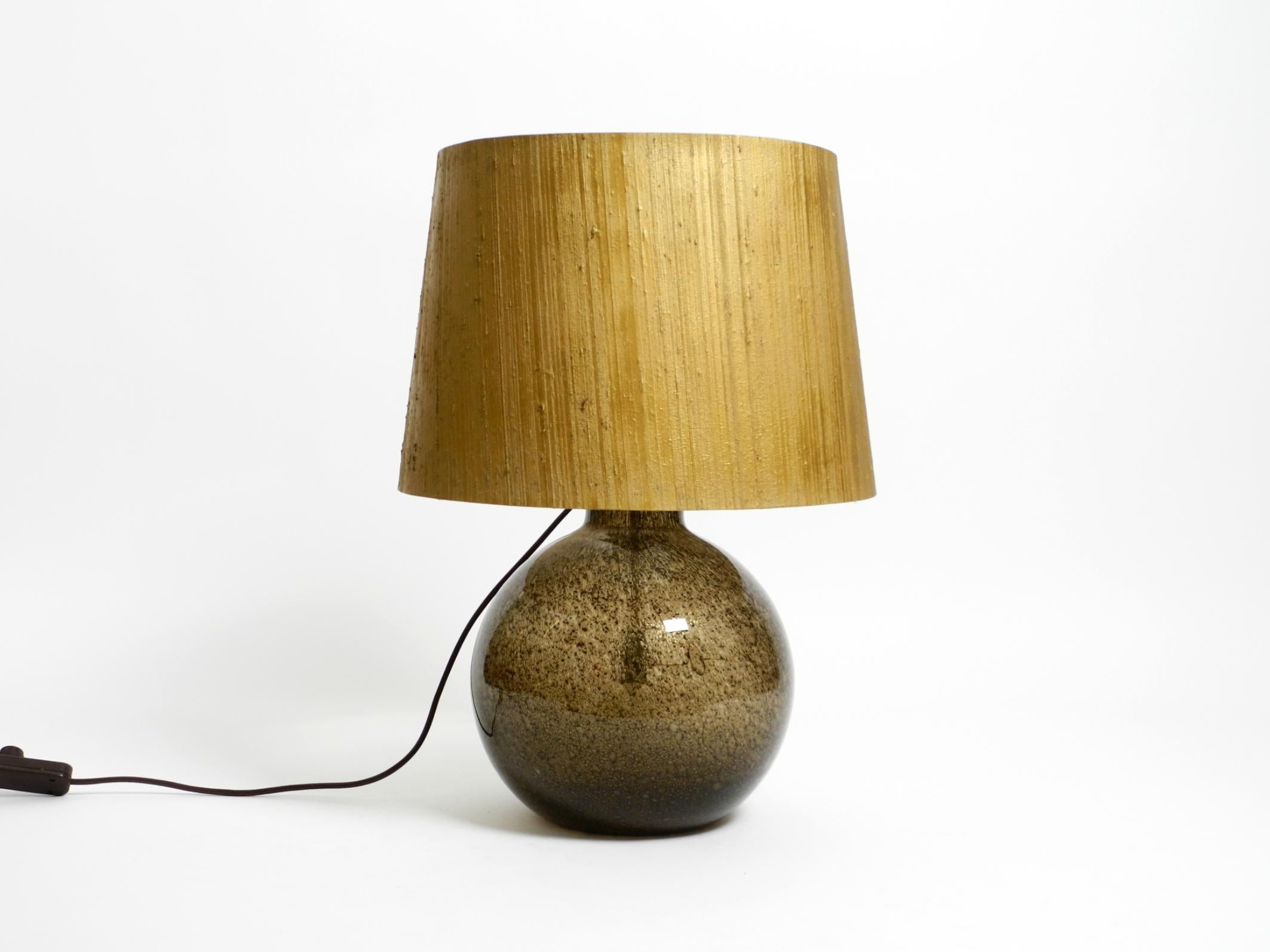 Large, elegant 1970s original Putzler table lamp.
With original label on one socket.
It has two sockets, one above and one in the glass base. Can be switched on together or separately.
Glass base is made of brown smoked glass with air bubbles. Large