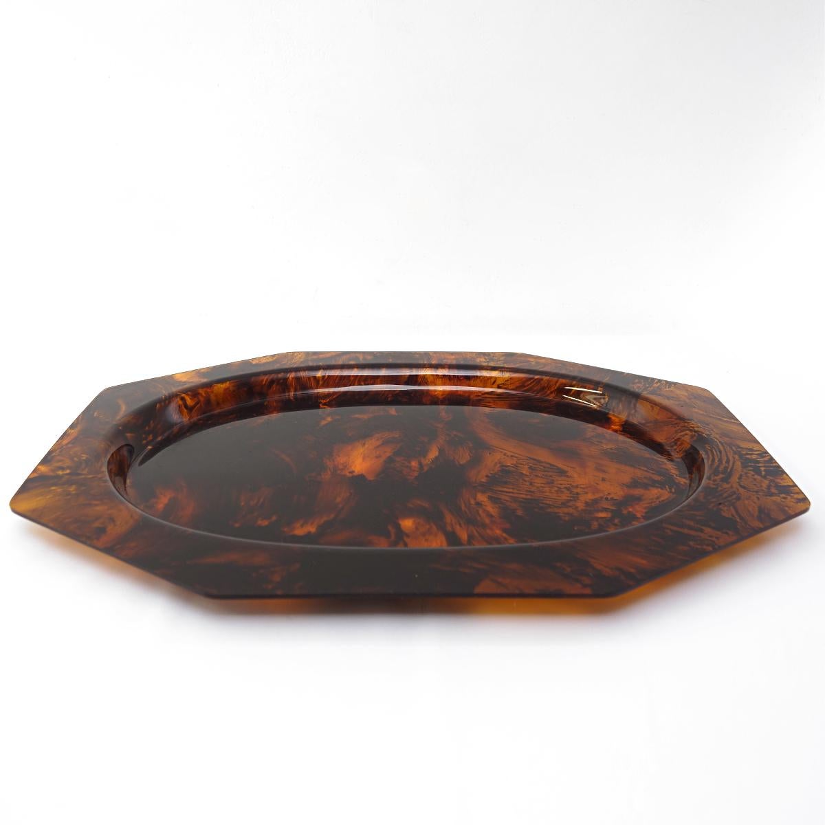 This large tray from the 1970s is round on the inside and octagonal on the outside. It is made of lucite that has been given a faux tortoise decor, the same decor the four matching plates were given. 

Measurements of the plates:
Diameter 33.5 cm,