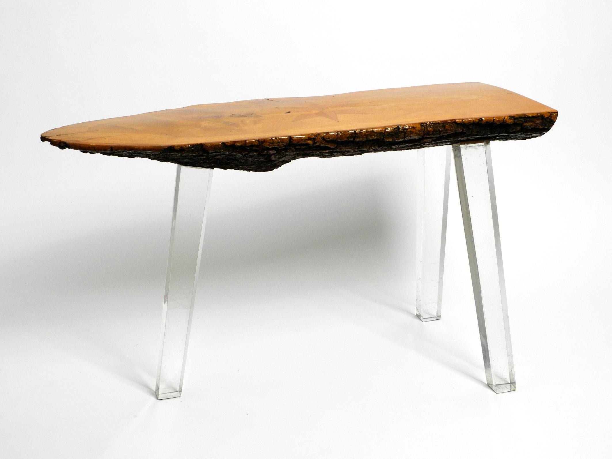 Magnifique table basse d'appoint au design Régence des années 70, fabriquée à partir d'une épaisse tranche d'arbre dont le dessous est recouvert d'écorce.
Entièrement recouvert de vernis transparent. 
Avec une belle incrustation en forme d'étoile