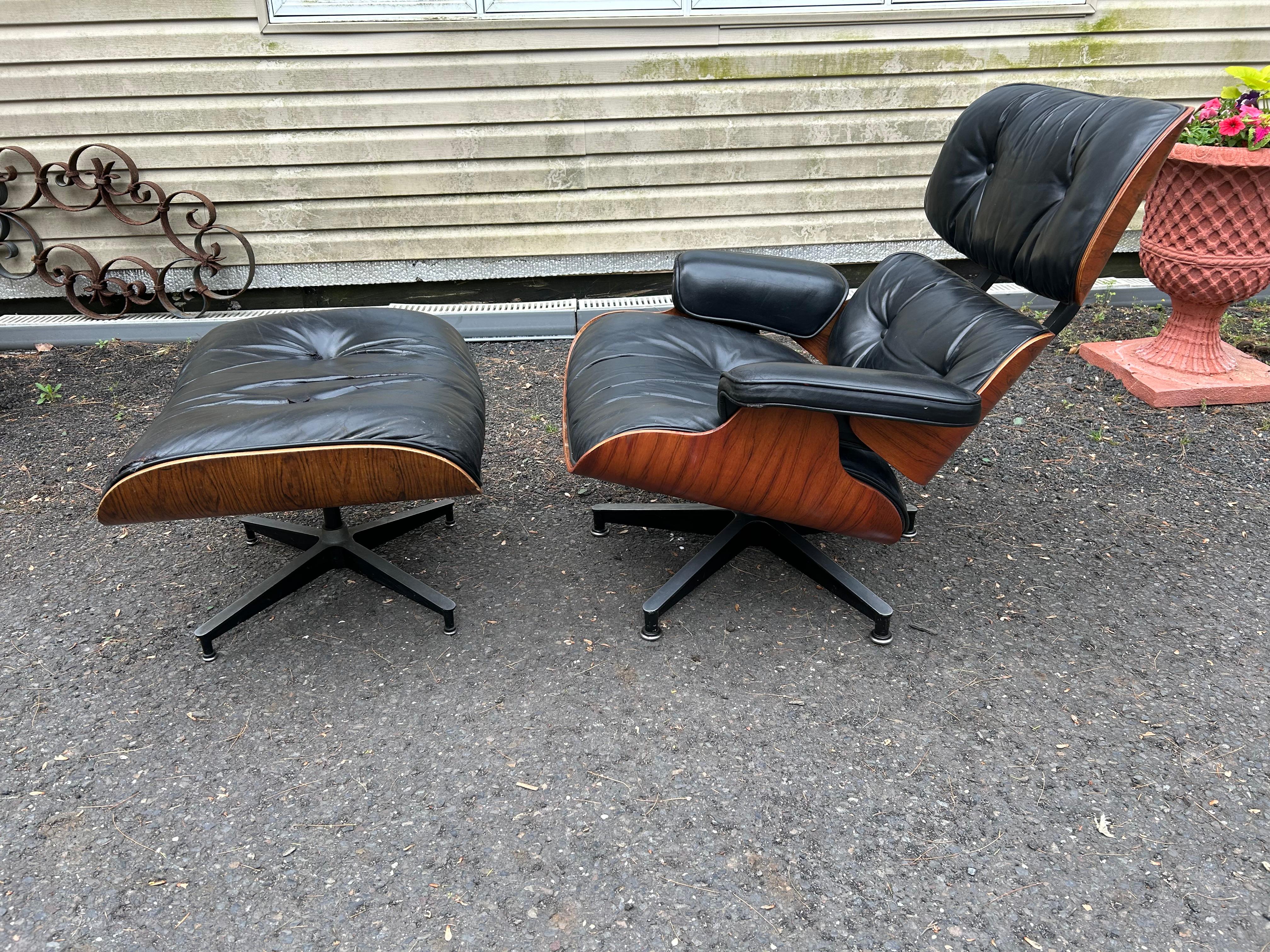 Handsome classic 70's Eames lounge chair and ottoman. Executed in rosewood and black leather. Cast aluminum bases, with adjustable “domes of silence” leveling glides. Extremely comfortable foam cushions.  Retains original leather in ok