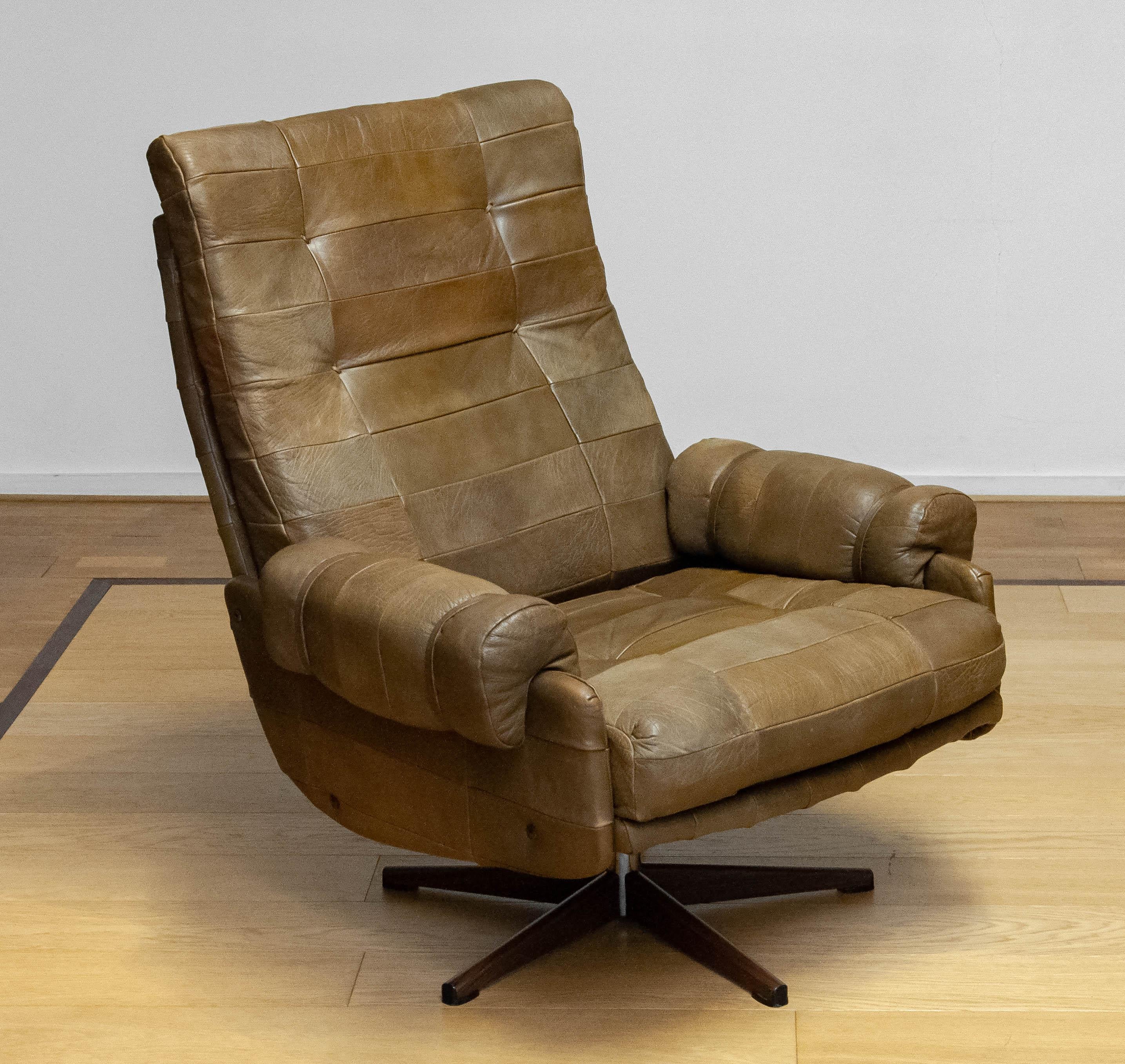 Extremely comfortable swivel chair by Arne Norell For Norell Möbler AB in Sweden. The chair is upholstered with beautiful and sturdy olive green ( patchwork ) buffalo leather. The chair supports great and is absolutely made for long seat / rest