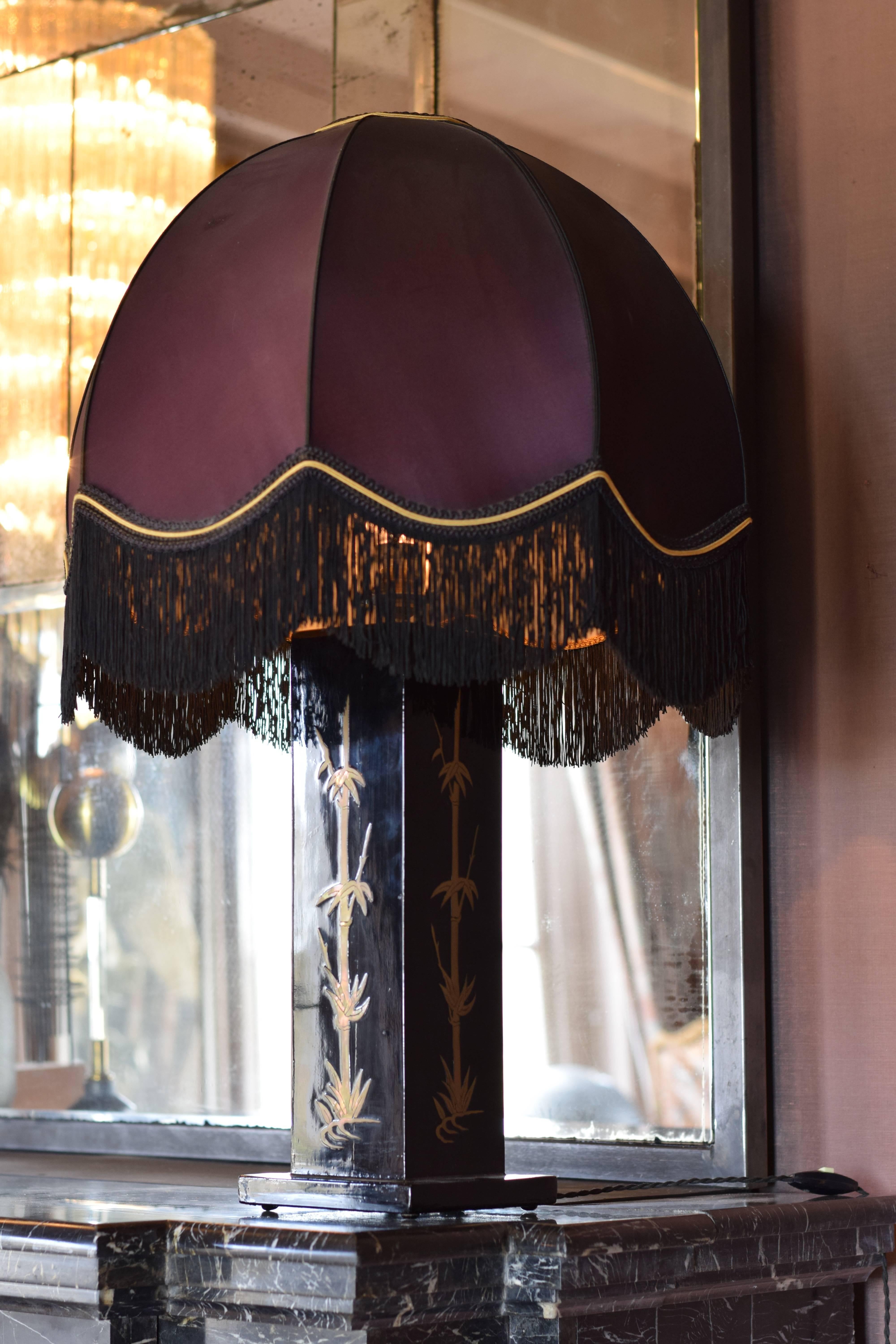 1970s table lamp on Japanese lacquer foot in the style of Jean Claude Mahey.
The lampshade has beautiful fringing. The fabric is in a good condition, although some slight discoloration can be noticed.
