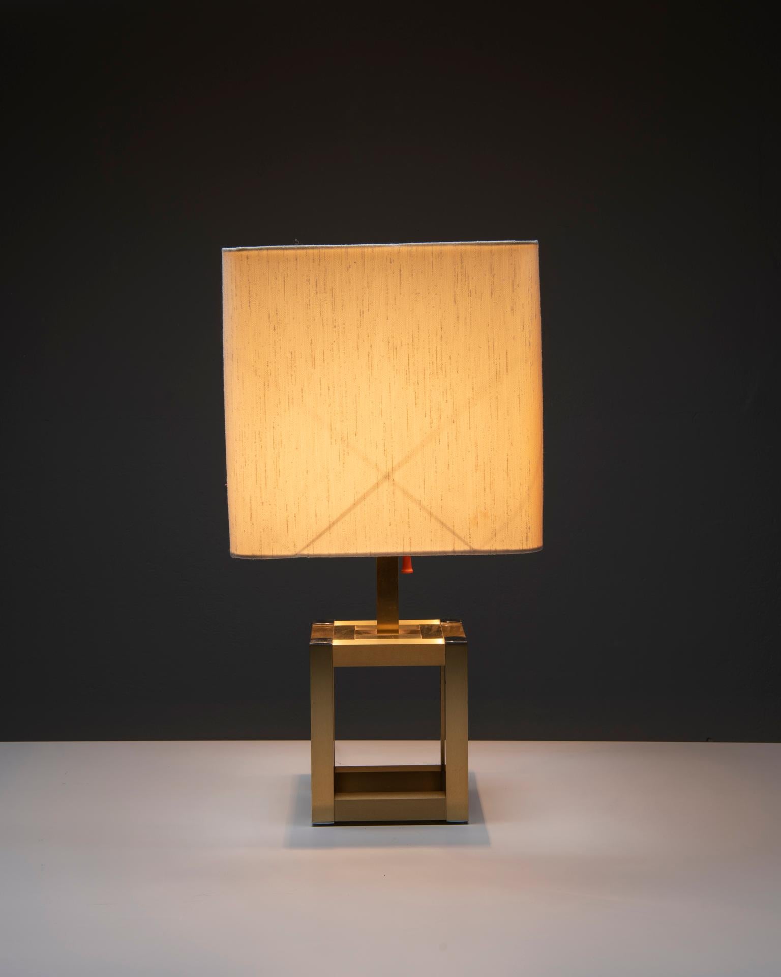 A vintage table lamp, made in the 1970s by BD Lumica (Barcelona, Spain). The lamp consists of a cubic brass base with chromed parts, and a beige shade. The socket holds 3 E27 bulbs, can be lit separately.
One side of the shade is a bit darker