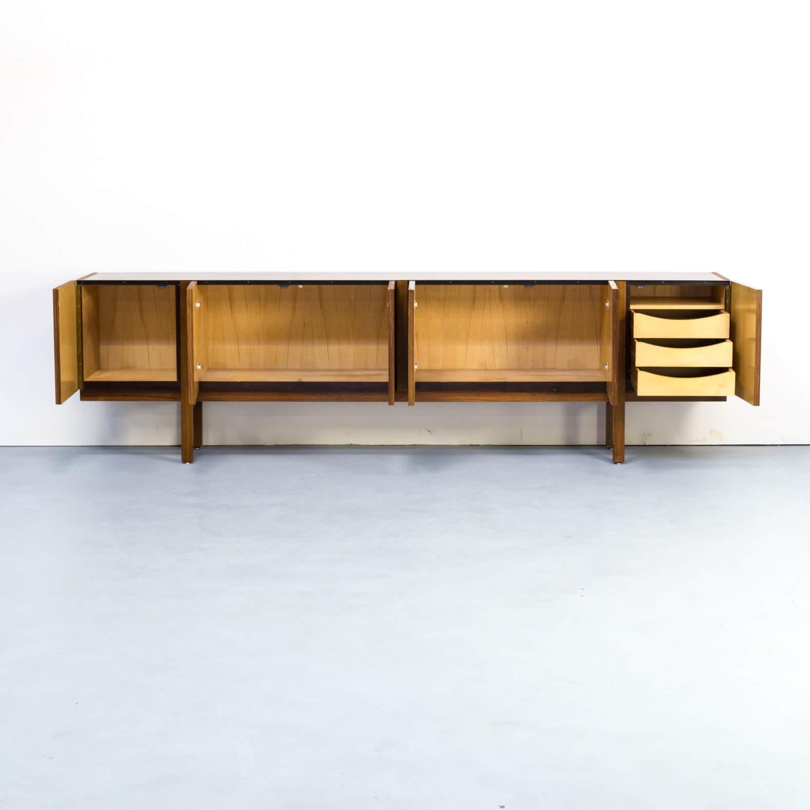 1970s teak veneer large credenza sideboard. Beautiful 1970s teak veneer 270cm large sideboard in minimalistic style. Sideboard has 6 handleless doors with 3 inside drawers behind one. The sideboard is carried by only 4 straight legs and the doors