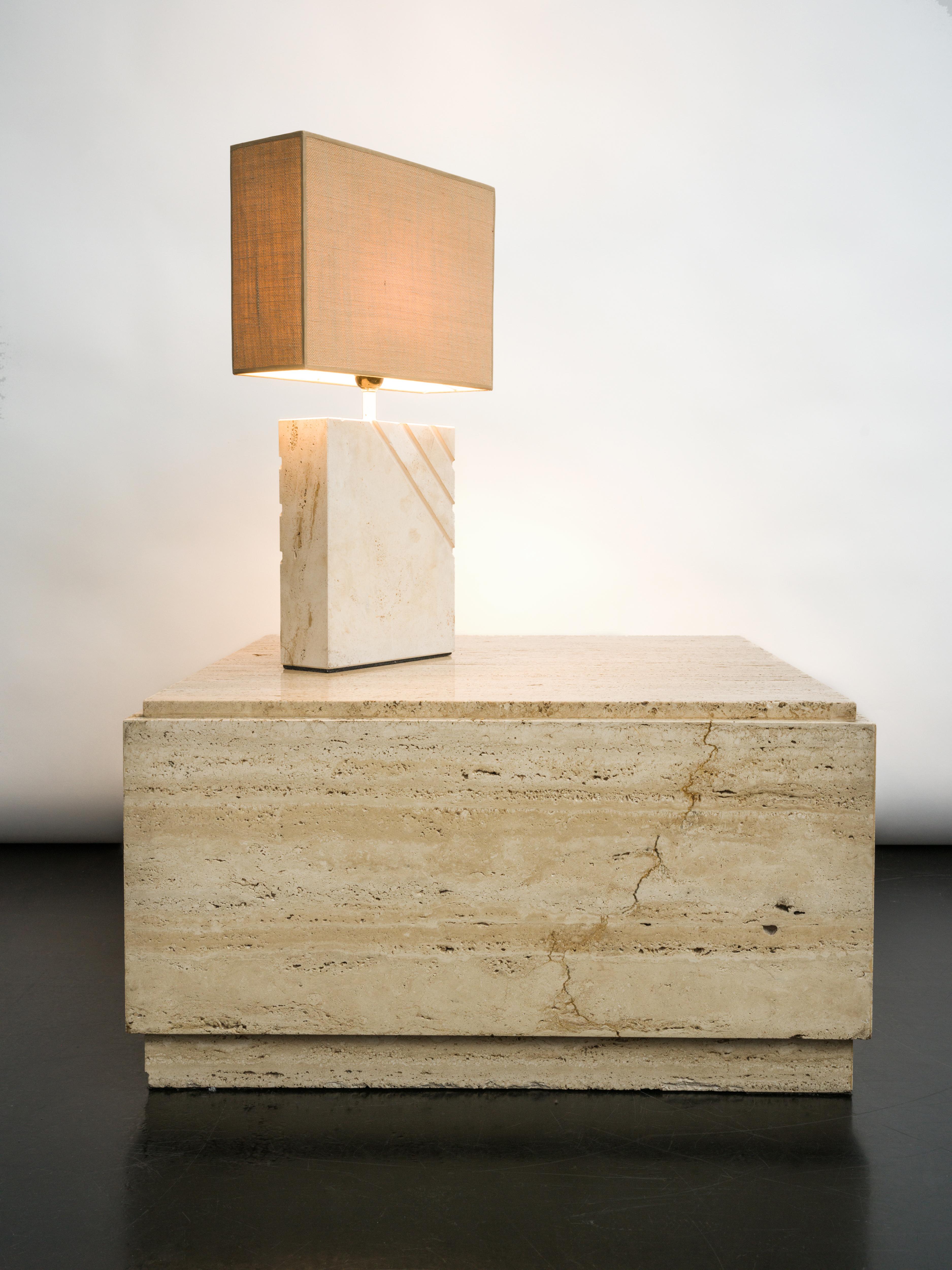 1970s travertine table lamp with rectangular lampshade. The textured shade blends perfectly with the beige stone.
A piece in light colors that will fit easily into your interior and will bring a soft light in the room. In love with its elegance