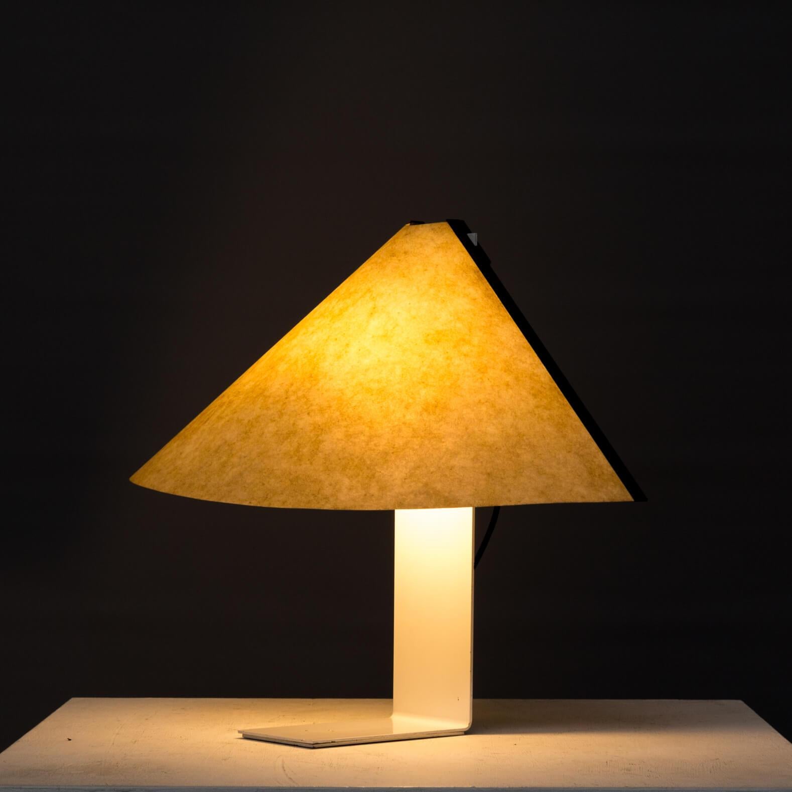 This artemide table lamp shows the experimental use of paper hooding just because Magistretti was inspired by the light fall behind papier. Lamp is in good and working condition.