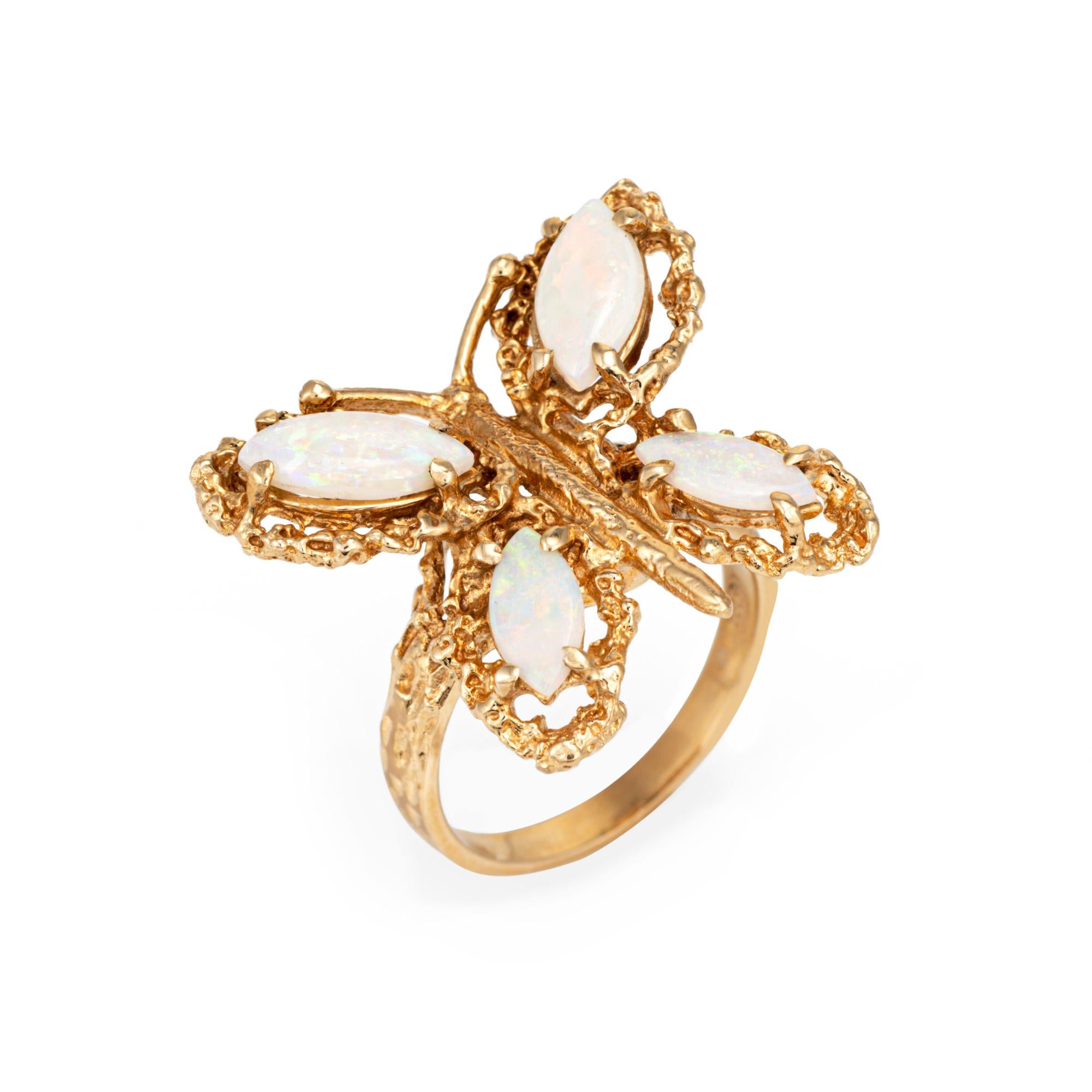 Élégante bague papillon en opale réalisée en or jaune 14 carats (vers les années 1970). 

Les opales mesurent 10 mm x 4 mm et 8 mm x 3 mm. Les opales sont en très bon état et ne présentent ni fissures ni éclats.  

Le design en forme de pépite met