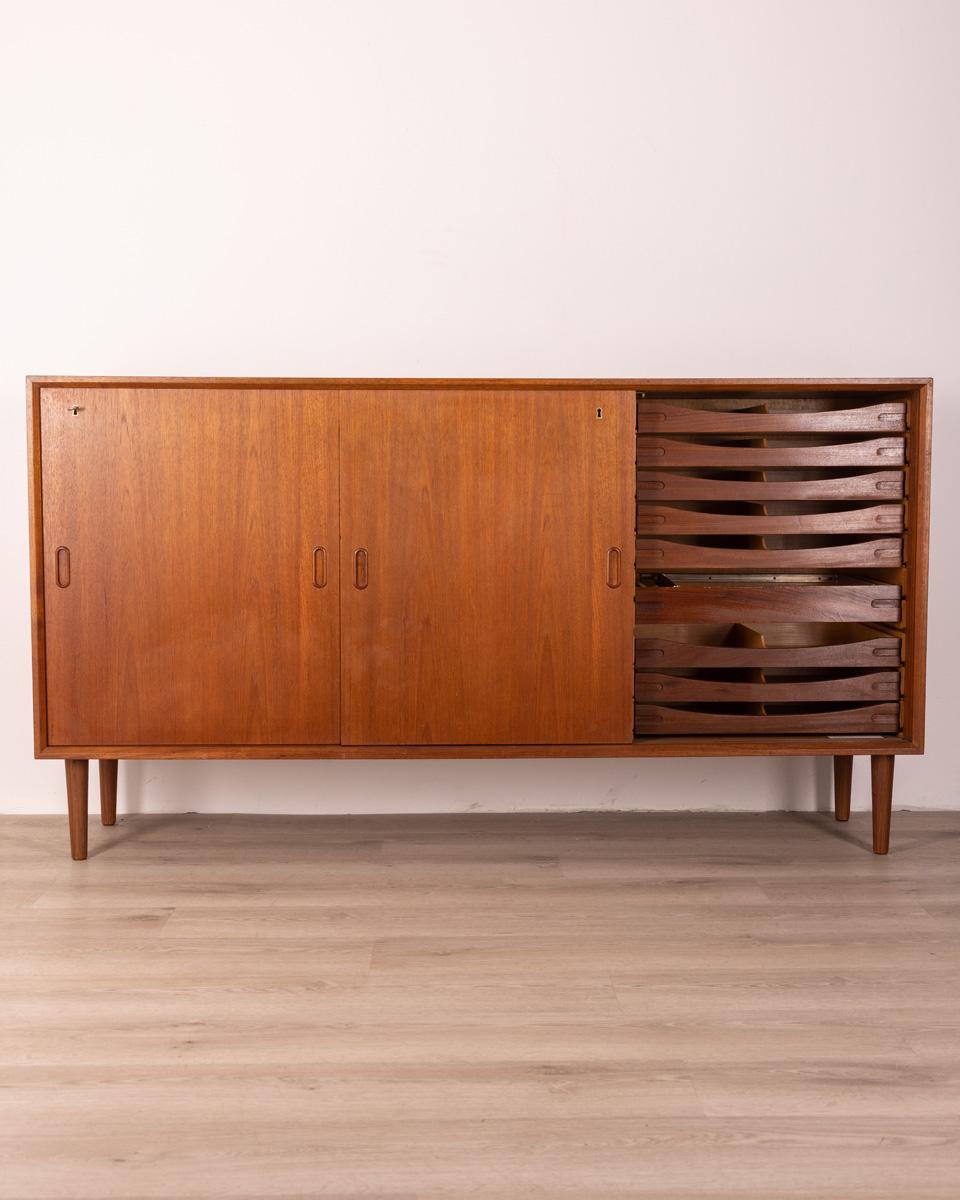Teak wood sideboard, has 19 internal drawers and three sliding doors; The external doors are equipped with a key lock. Danish design, 1970s.

Conditions: In good condition, it shows signs of wear given by time.

Dimensions: Height 93 cm; Width