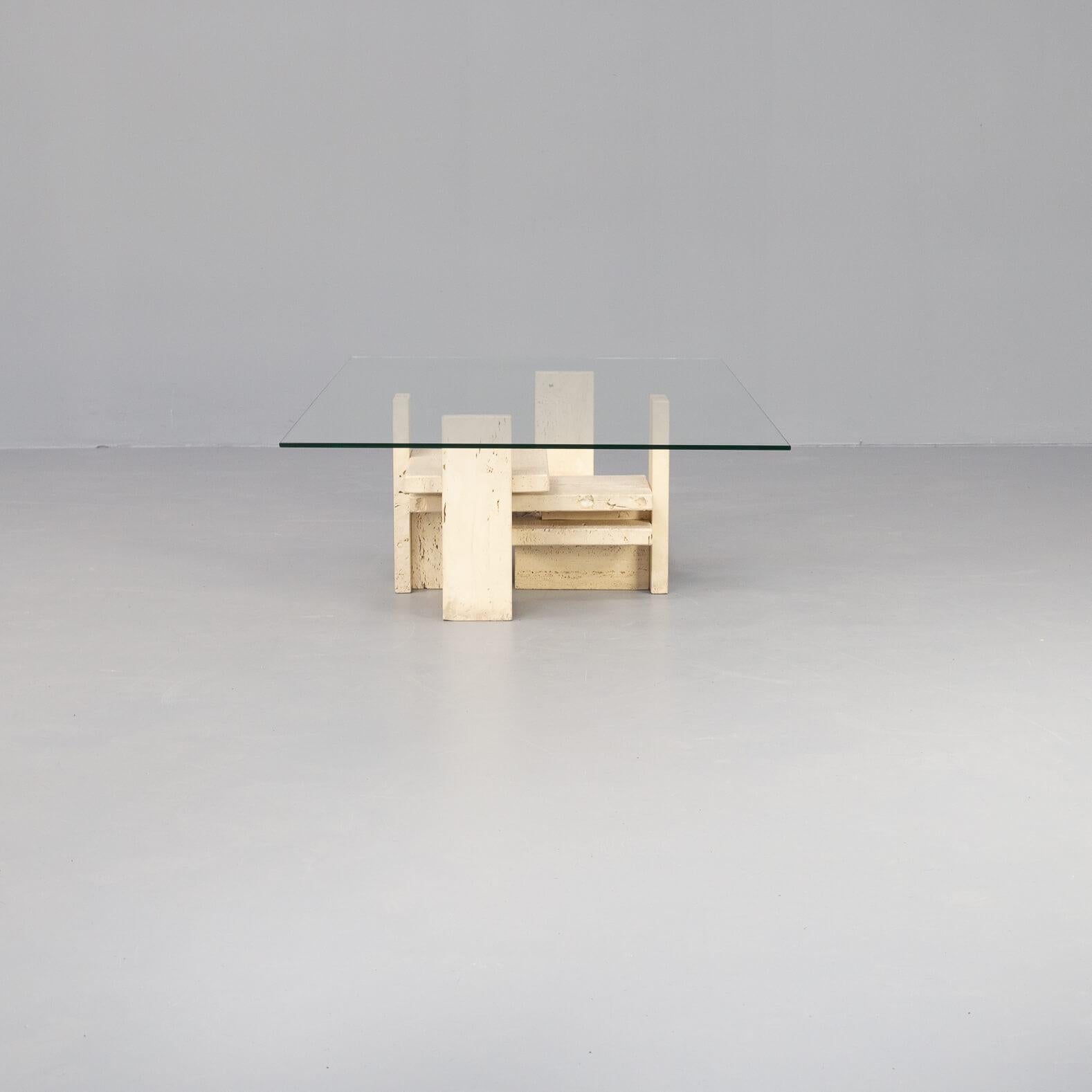 Very nice sculptural coffee table designed and made by Studio Willy Ballez, Belgium 1970. This table has a solid travertine base and a thin rectangle glass top. The table has a beautiful modernist shaped base and is in good condition. All Willy