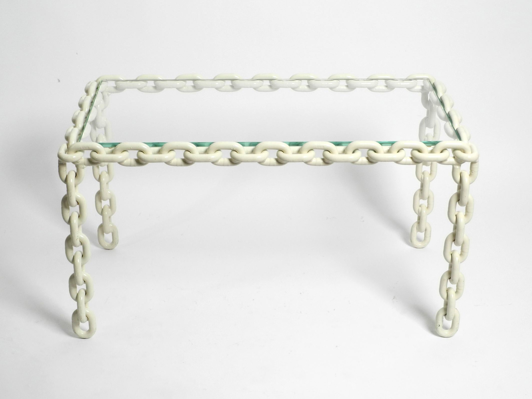 Beautiful, very rare and heavy coffee or side table made of white lacquered heavy maritime ship chains welded together.
The plate above is a cut thick clear glass in very good condition.
Great brutalist design from the 1970s. Manufacturer is
