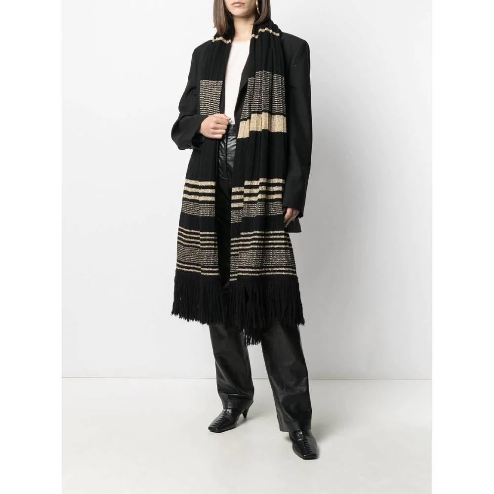 Yves Saint Laurent black wool scarf. Striped motif with golden lurex threads and fringes.

Measurements
Length: 204 cm
Width: 76 cm

Product code: A6059

Notes: The item shows some pulled threads.

Composition: 90% Wool - 10% Metallic fibres

Made