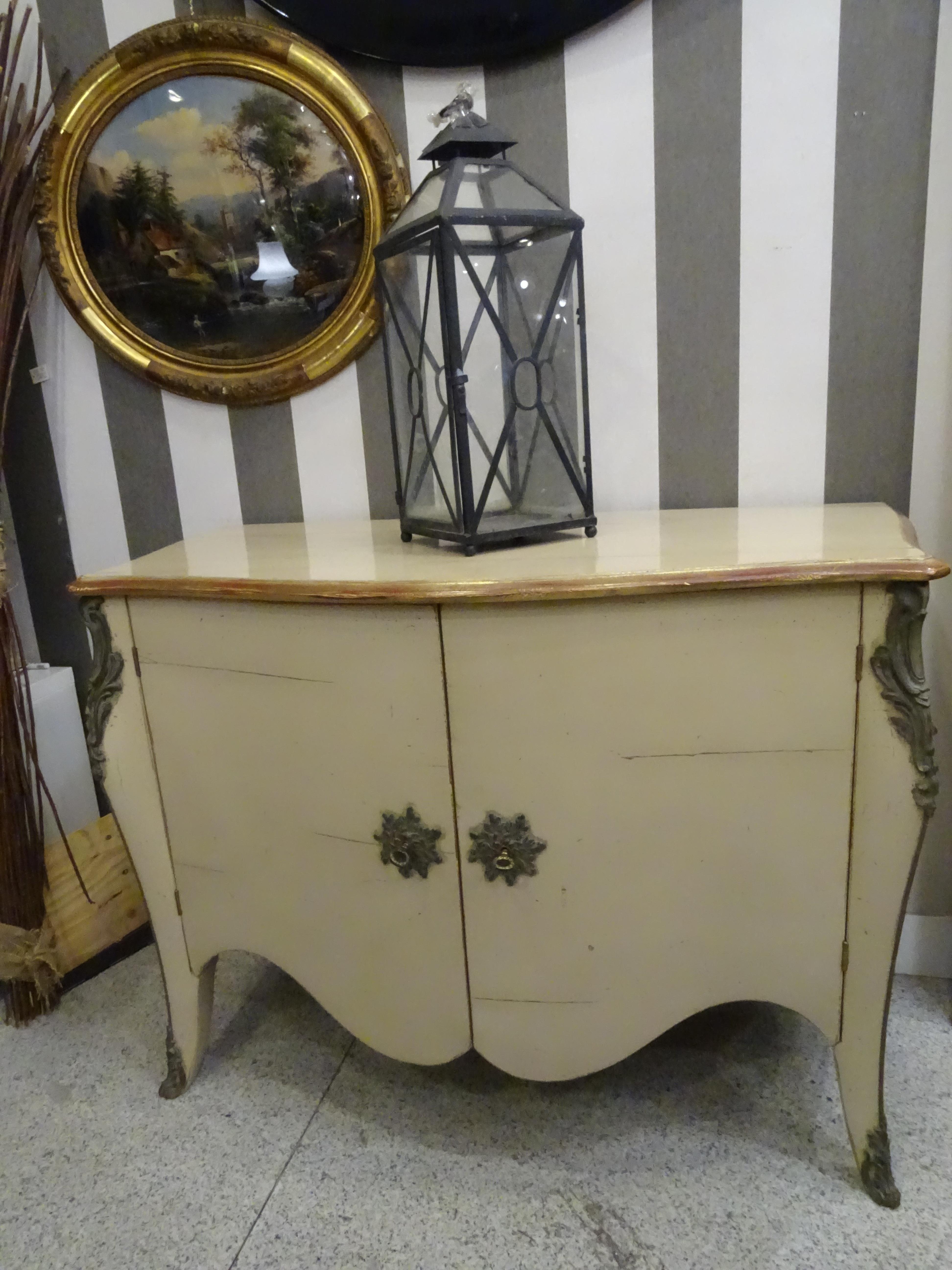 Gorgeous Chest of drawers or commode in off white wood in the Provencal style, Louis XV, , with aged bronzes in the corners . Front bulge and corrugated inner skirt. 
With 2 doors and one lock with keys . Inside with shelves .Roche Bobois piece made