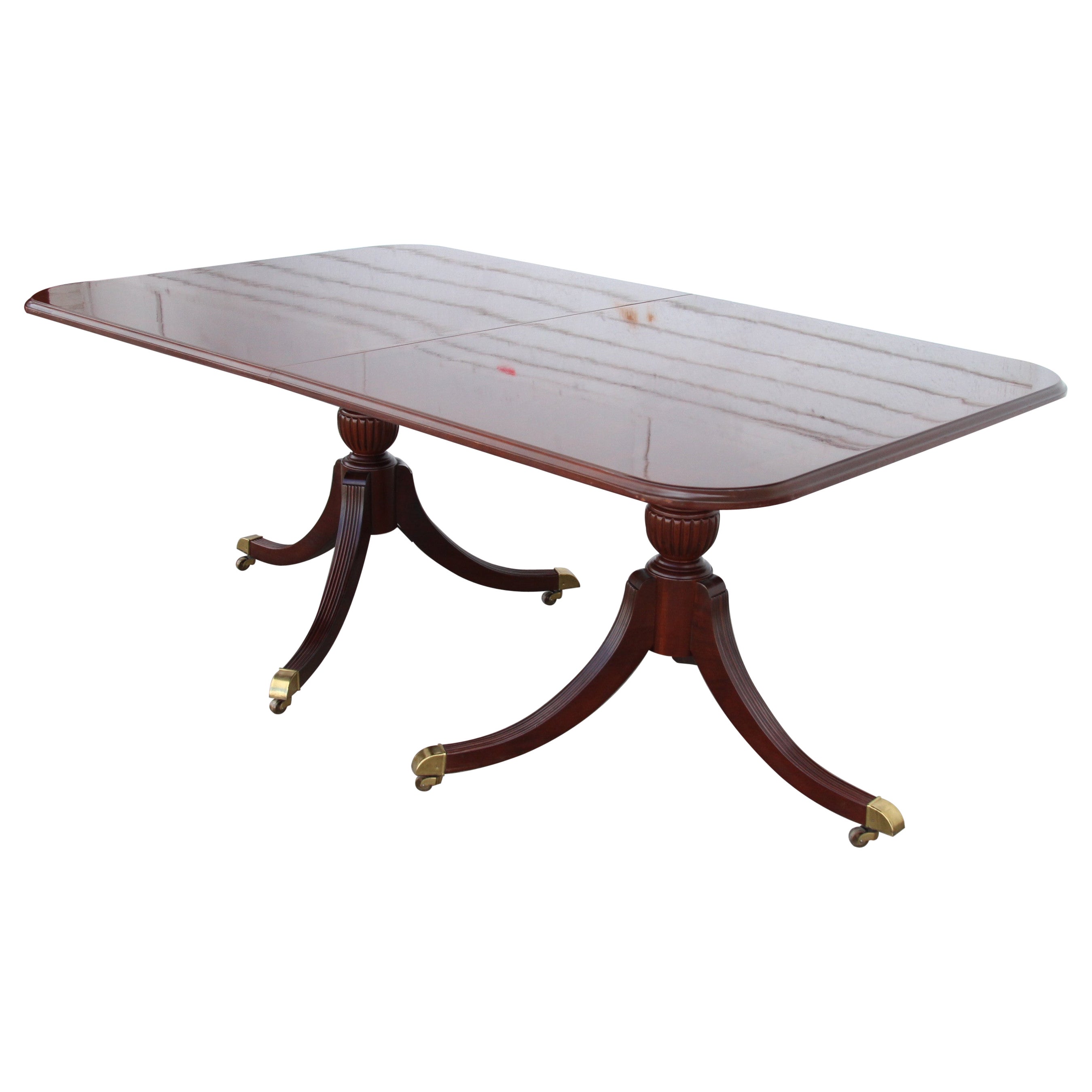 Regency Style Antique Pedestal Table
Circa 1967

American Regency style mahogany veneered dining table with a satinwood banded top. Extends with 1 leaf and on two turned column pedestals. Brass cappings and castors. 

Size:

Table 
71