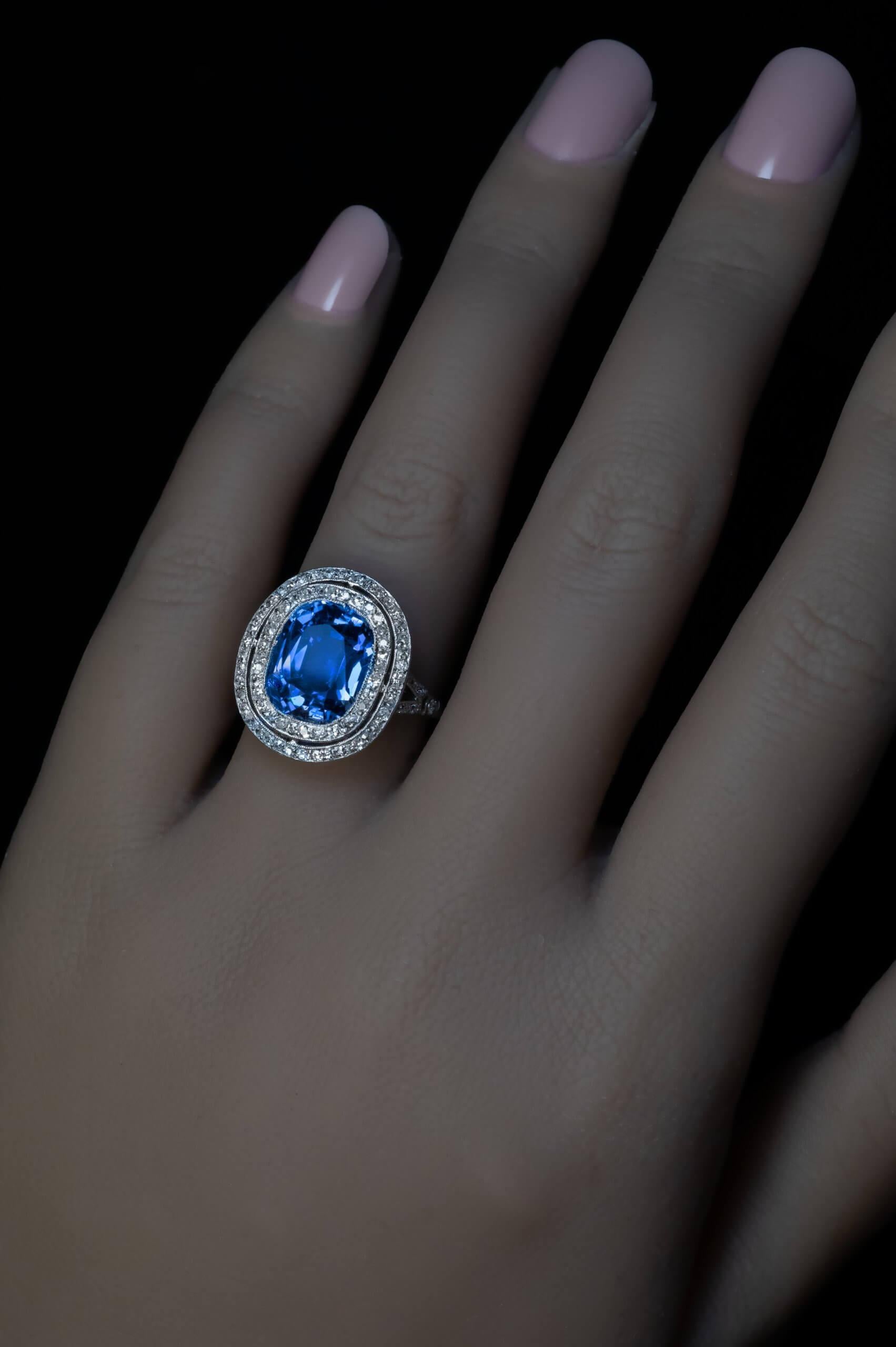 Circa 1910s  The ring is finely crafted in platinum. It features a natural unheated cushion cut sapphire from Ceylon of a very nice blue color framed by a double halo of old cut diamonds. The sapphire is eye clean, has excellent sparkle, color