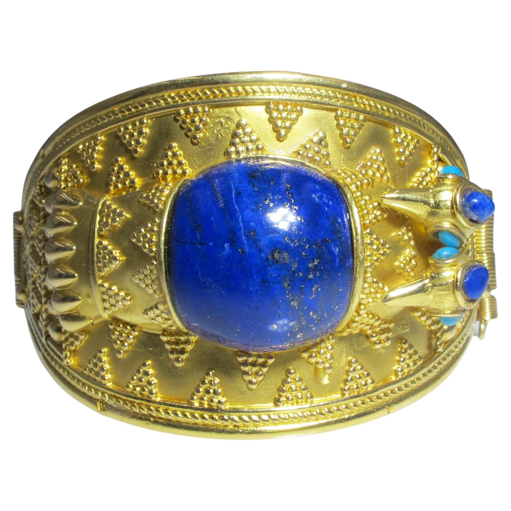 71.08 GR 18KT GOLD HAND CARVED BEETLE DESIGN WITH LAPIS  AND TURQUOISE VERY RARE!
Appraisal Value $11,950+TAX
CENTER STONE: LAPIS CABACHON
SHAPE: HAND CARVED BEETLE DESIGN 
CENTER STONE: APPROXIMATELY 21MM X 21MM AND 2 SMALL LAPIS CABOCHONS 
STONE:
