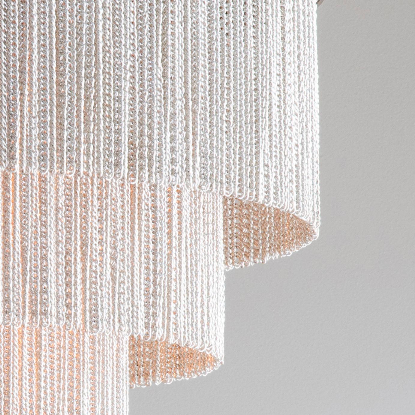 Contemporary chandelier with three shallow tiers of delicate chain strands and handcrafted metalwork. Available in bronze, gold or flat nickel metalwork with either black or silver decorative chain.

Designed and handmade by Tigermoth Lighting on