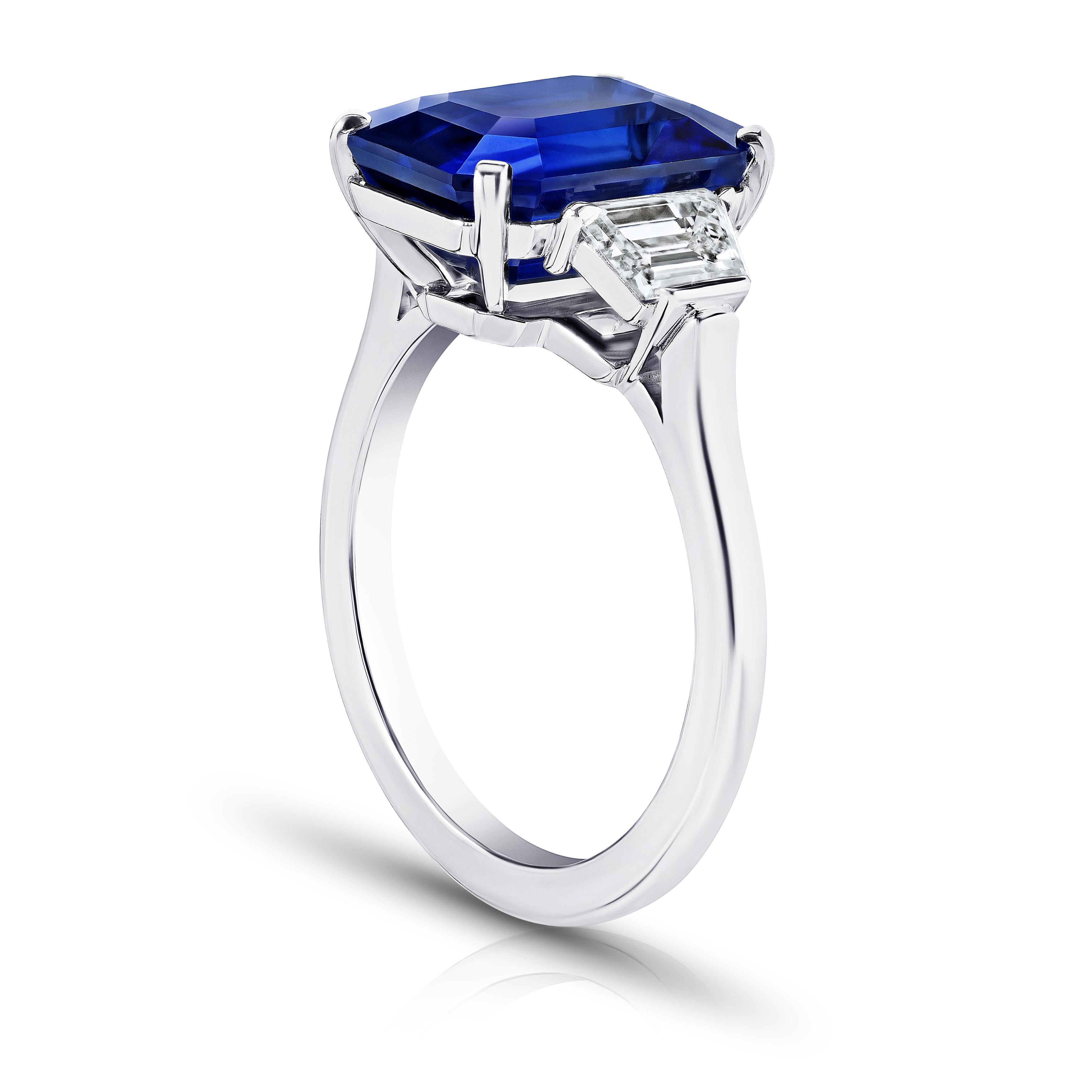 7.11 carat emerald cut blue sapphire with trapezoid diamonds .88 carats set in a handmade platinum ring. This ring is currently a size 7.  We will resize to your finger size without charge.
