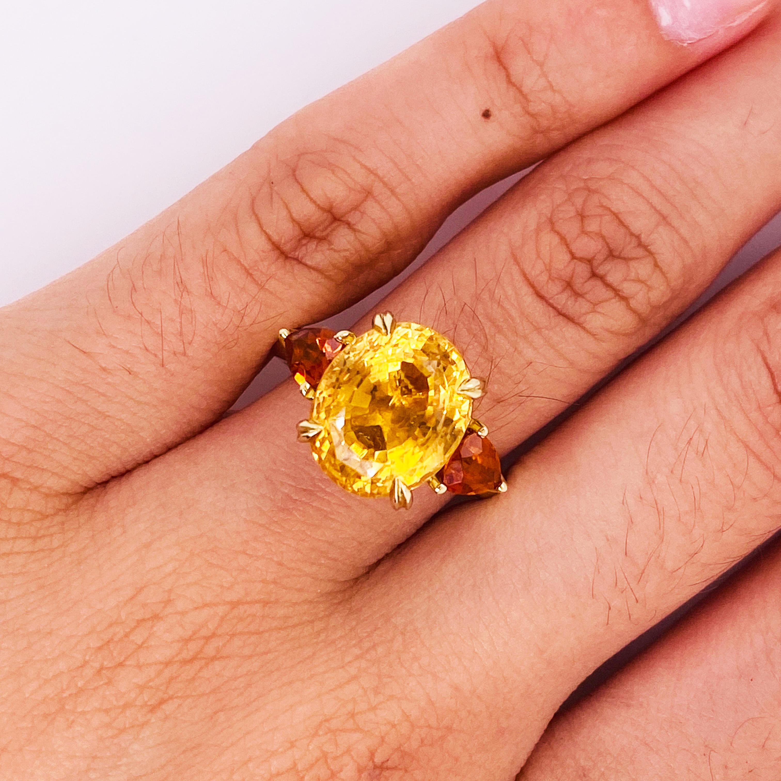 Adorn a magnificent finger with this gorgeous citrine three-stone ring! Celebrate a loved one with oranges that speak of tropical sunsets, honey, and the warm glow of an evening by a fire. The large oval golden honey orange citrine is beautifully