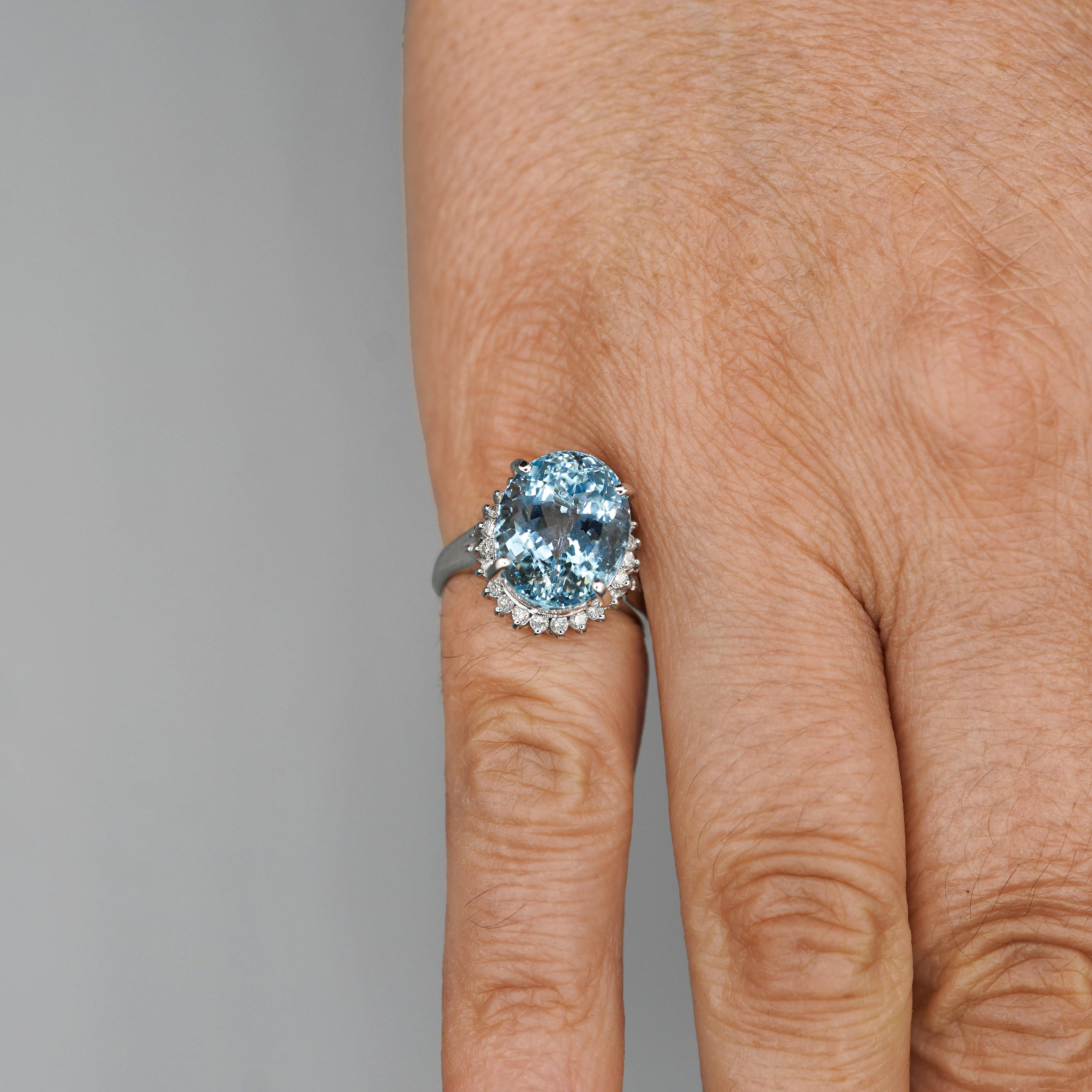 Questo squisito anello in platino 900 con acquamarina ovale da 7,15 carati, misura 13,2 x 10,5 mm ed è circondato da diamanti per un peso totale di 0,33 carati. I diamanti sono incastonati intorno all'acquamarina, esaltandone la brillante tonalità