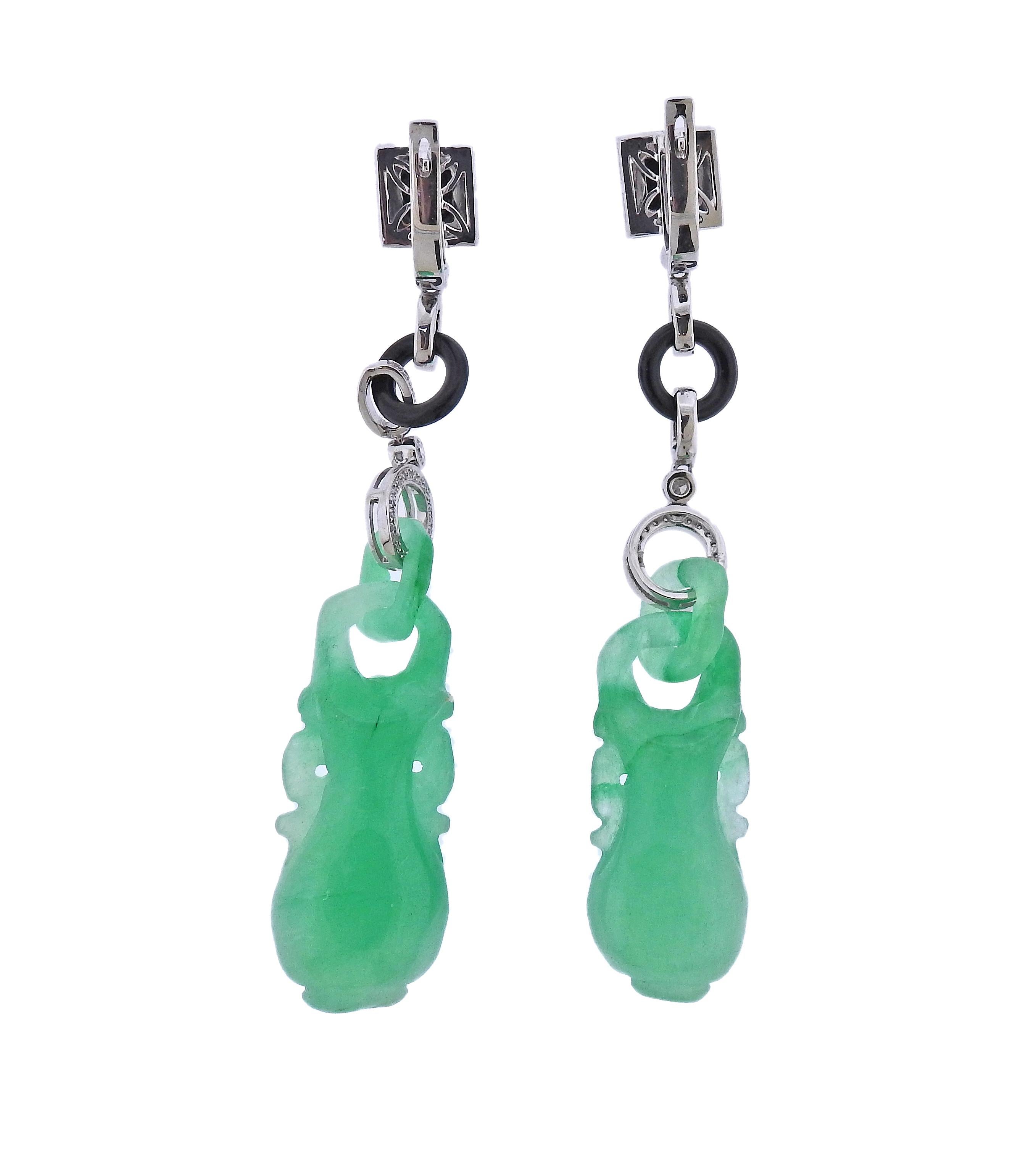 Pair of 18k gold drop earrings, with carved 71.60ctw jadeite jade, onyx and 0.29ctw in diamonds. Earrings are 71mm long. Marked 750. Weight - 22.5 grams.