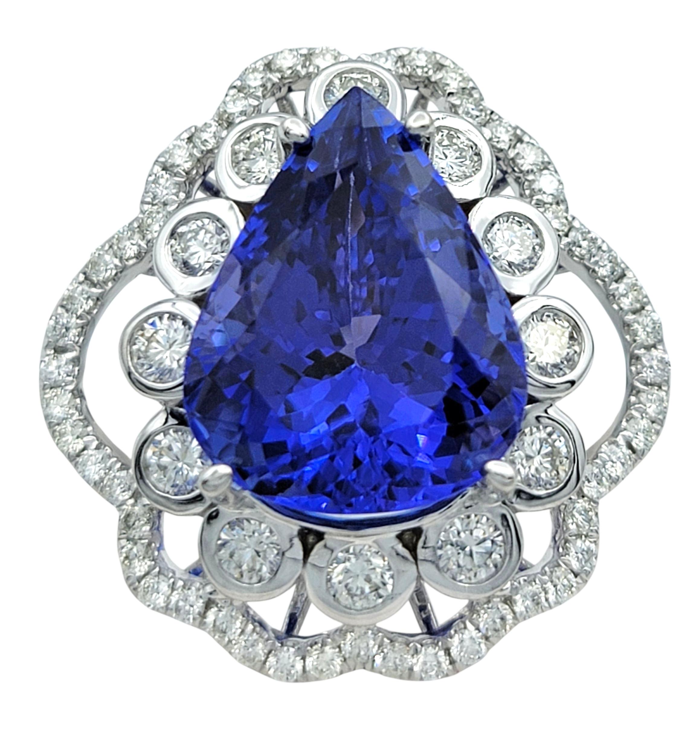Questo anello mozzafiato presenta al centro una tanzanite a forma di pera profondamente satura, che irradia un'intensa tonalità blu-viola che cattura e riflette la luce con una brillantezza impressionante. Incorniciata da un'abbagliante aureola di