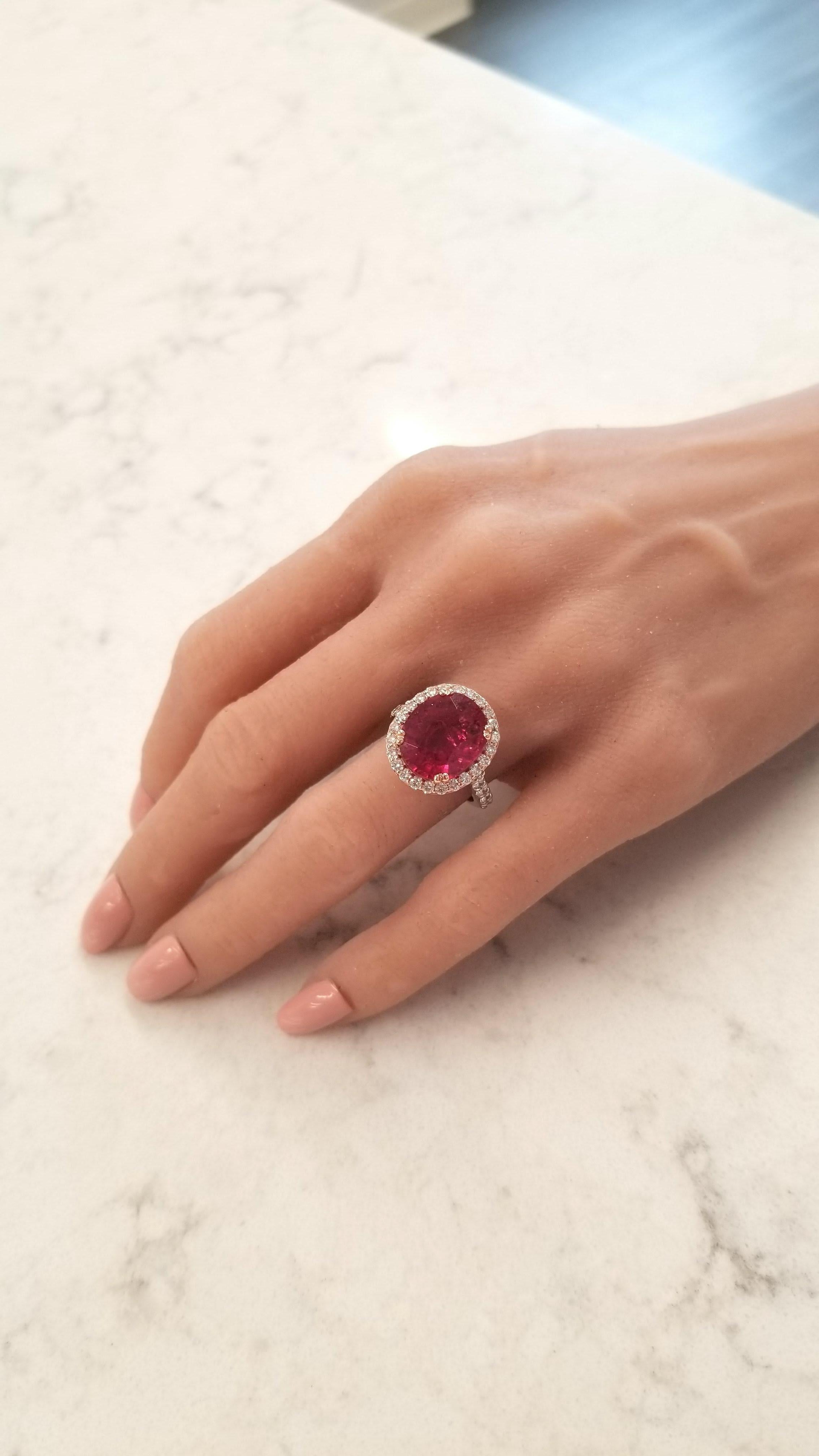 This is a 7.19 carat oval cut vibrant raspberry rubellite tourmaline and measures 11.68 X 13.80mm. The gem source is Brazil; its color is vivid, its transparency and luster are excellent. The intense color is framed by 34 sparkling round brilliant