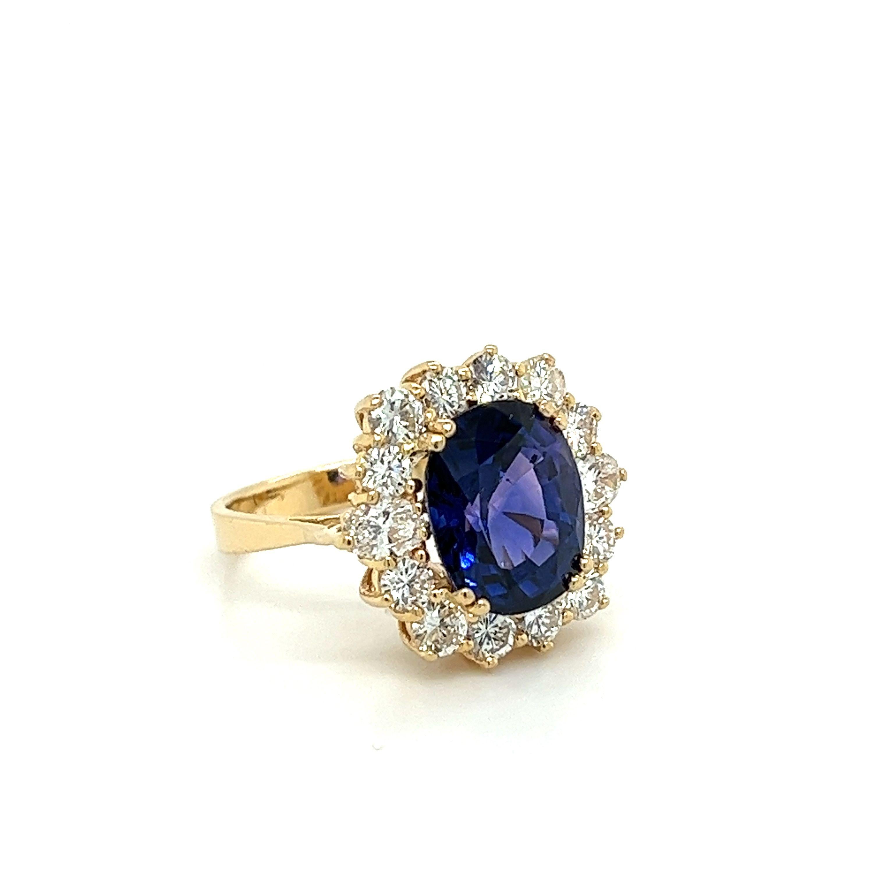 7.2 carat oval cut natural Blue Sapphire and round/oval diamond halo ring in 14 karat yellow gold. The sapphire truly radiates a vivid, rich blue color hue, especially under sunlight. The mixed-cut round and oval shape diamond halo offer excellent