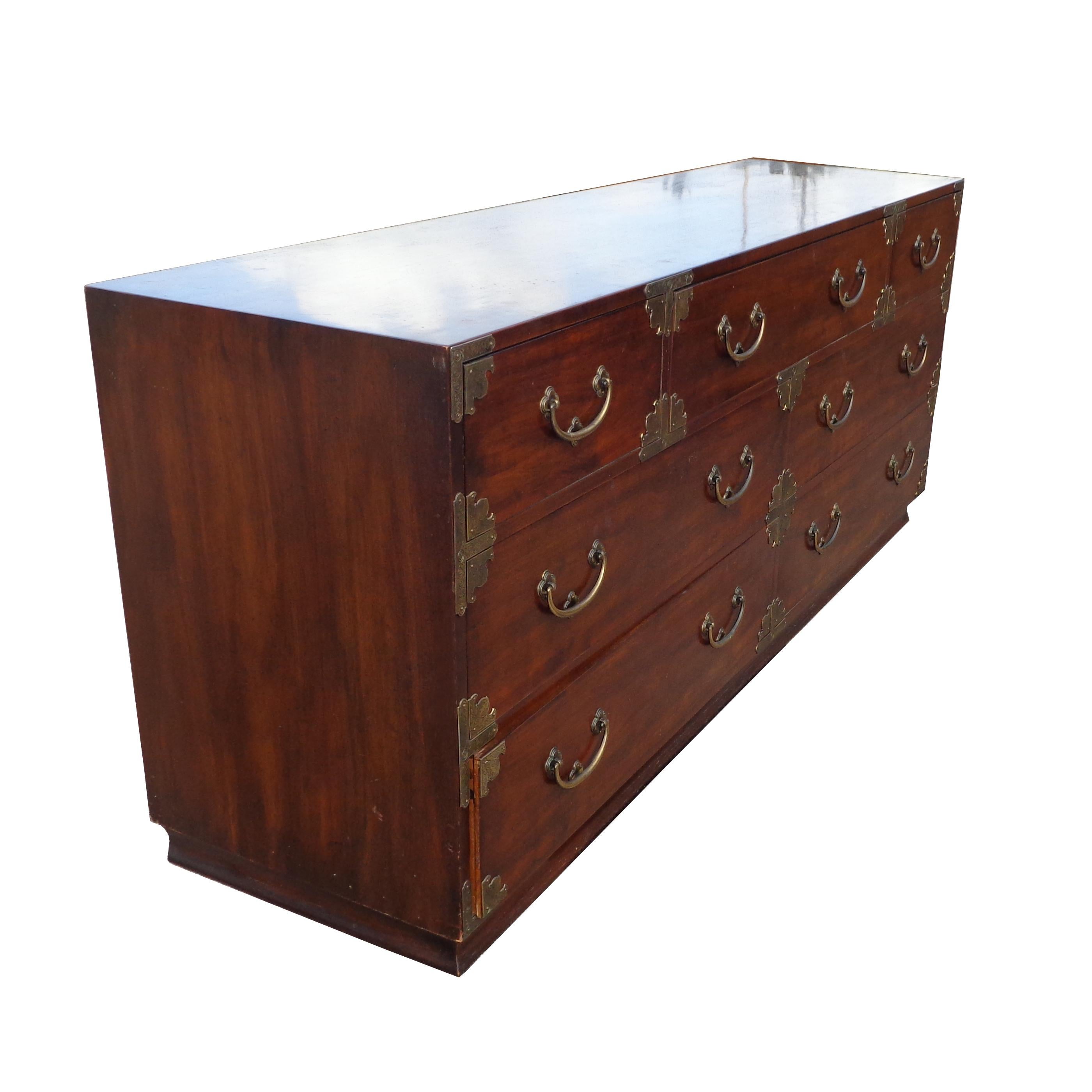Henredon Tansu Campaign dresser 

A dresser in the Japanese Tansu campaign style. Made by Henredon circa 1979. 
7 drawers. Features plinth base on the bottom. Walnut with brass hardware and Ming accents. 
See high boy also available. 

Measures 78