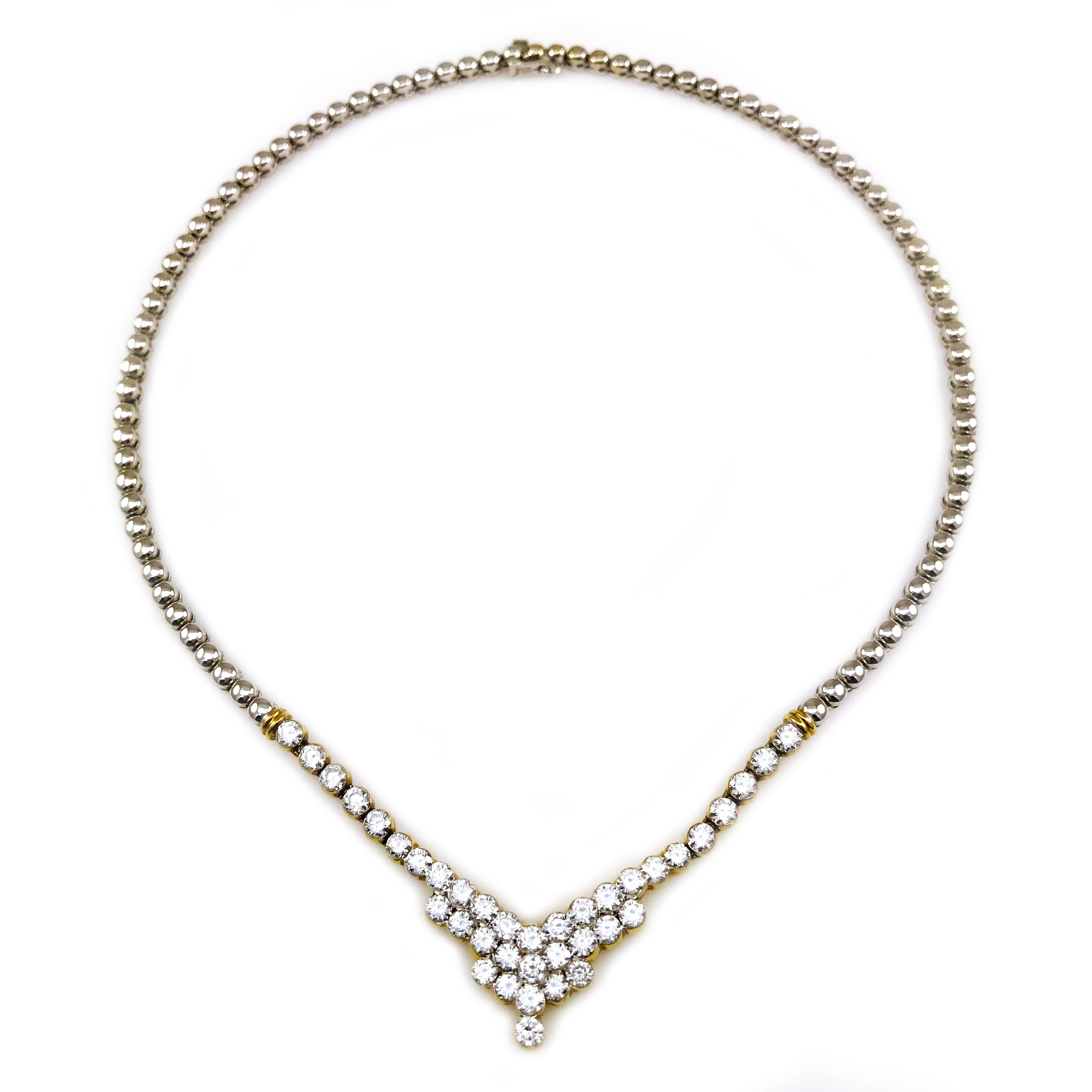 The electronically tested necklace features a chevron-style diamond motif, bordered by yellow gold stationed ridges, supported by a designer style white gold flexible chain, terminating in a concealed clasp with safety. Bright polish finish with