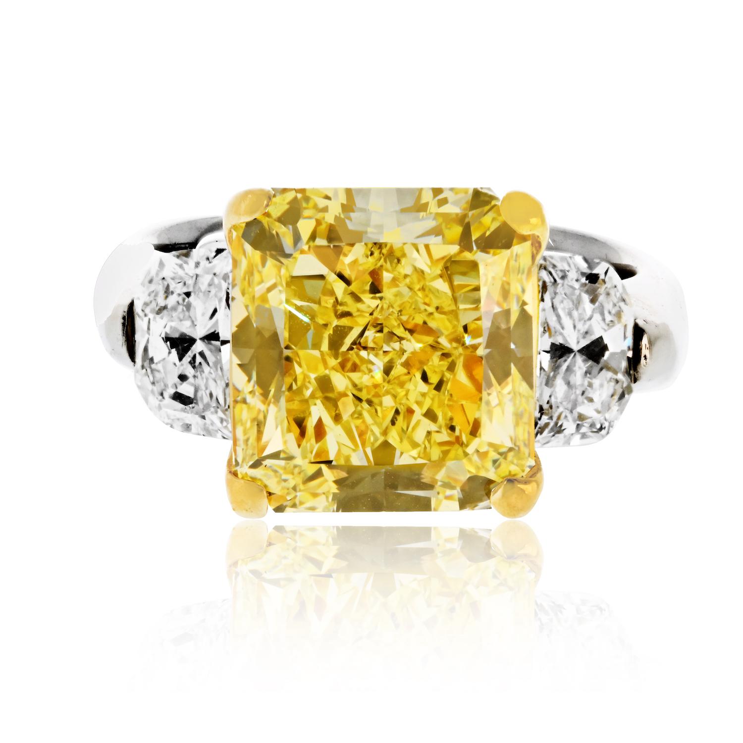 This exquisite three-stone diamond engagement ring is a breathtaking blend of platinum and 18K yellow gold. The centerpiece is a stunning 7.20-carat Radiant Cut diamond, certified as fancy intense by GIA (Certificate No. 11390364), showcasing