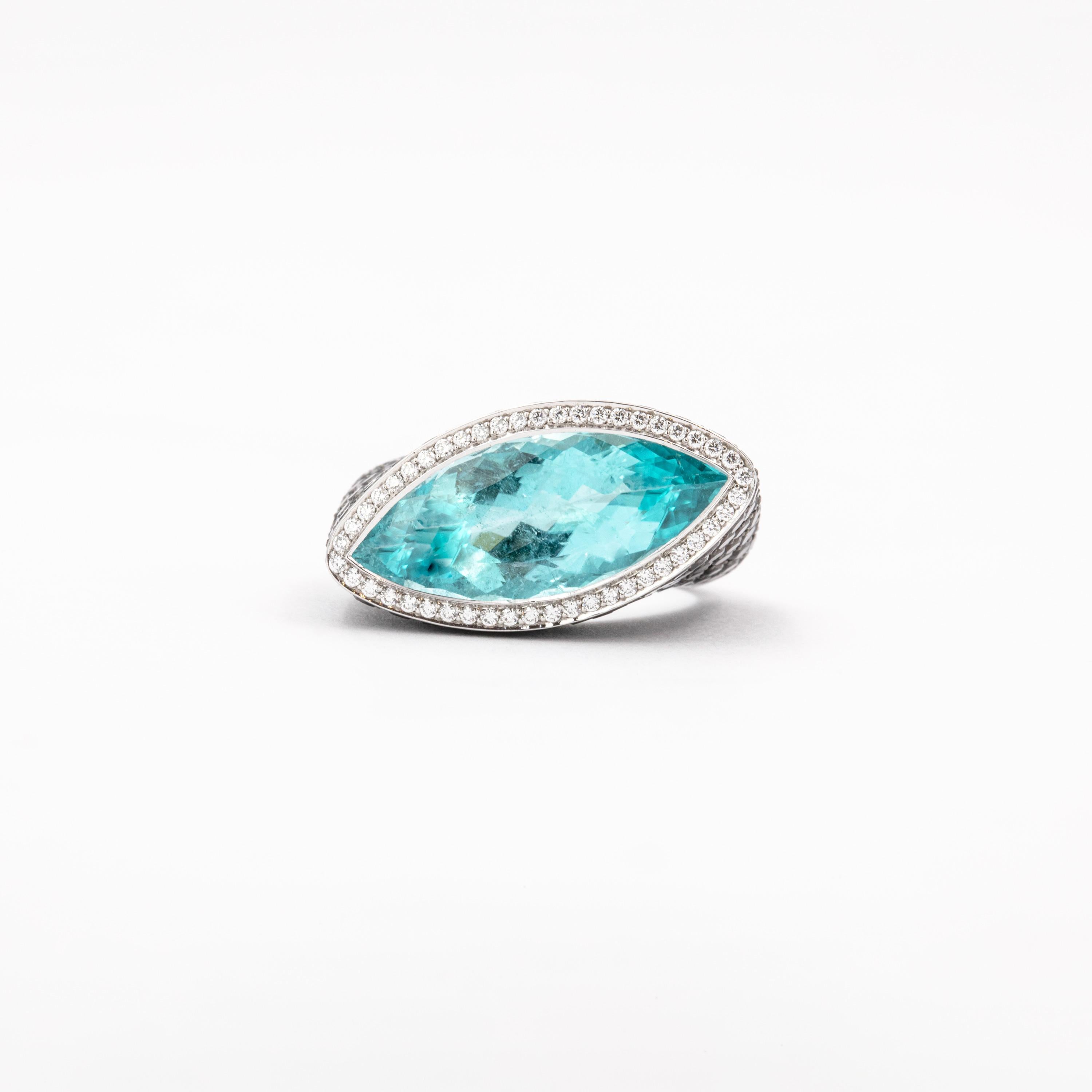 A slightly twisted shank studded with 152 black diamonds weighing 3.44 carats highlights the 7.22 carat marquise-shaped Paraiba Tourmaline. The vibrant center stone is set with a halo of 47 white, round brilliant-cut diamonds (F / VVS), which