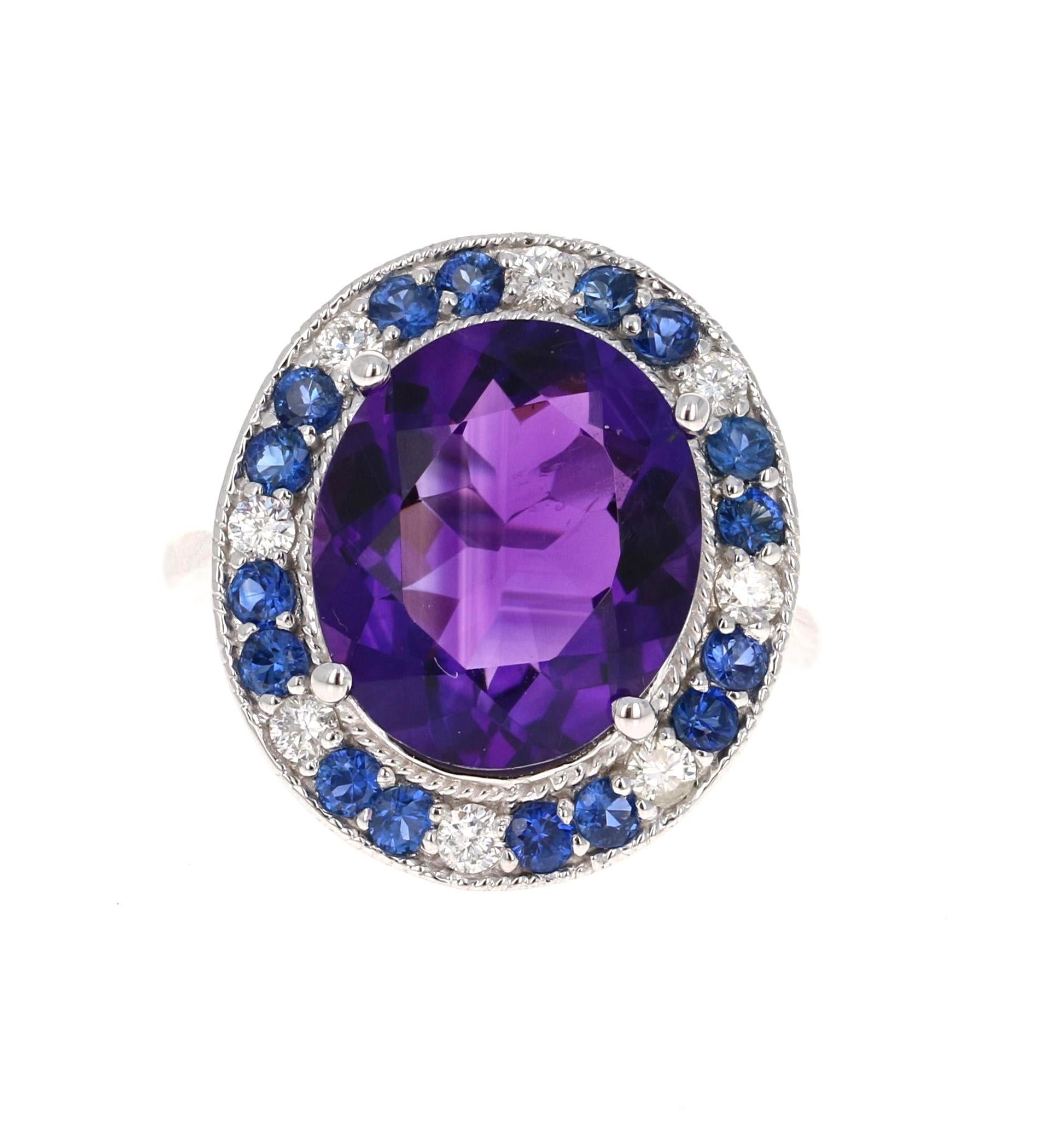 This beautiful and unique ring has a 6.10 Carat Oval Cut Deep Purple Amethyst and is surrounded by alternating Round Cut Diamonds that weigh 0.32 carats  (Clarity: SI, Color: F) and Blue Sapphires that weigh 0.81 carats. The total weight of the ring