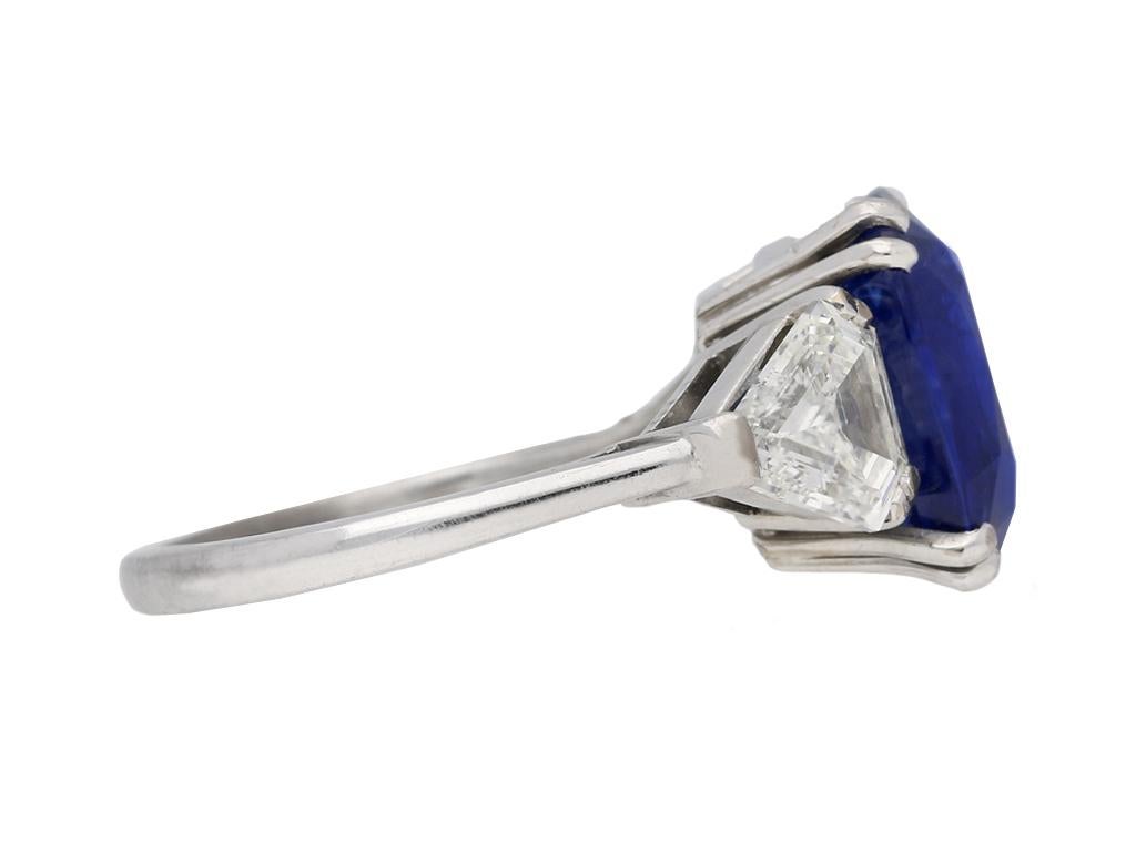 Natural Royal Blue Burmese sapphire and diamond ring. Set with a cushion shape old cut natural unenhanced Royal Blue Burmese sapphire to centre with an approximate weight of 7.23 carats in an open back double claw setting, flanked by two outward