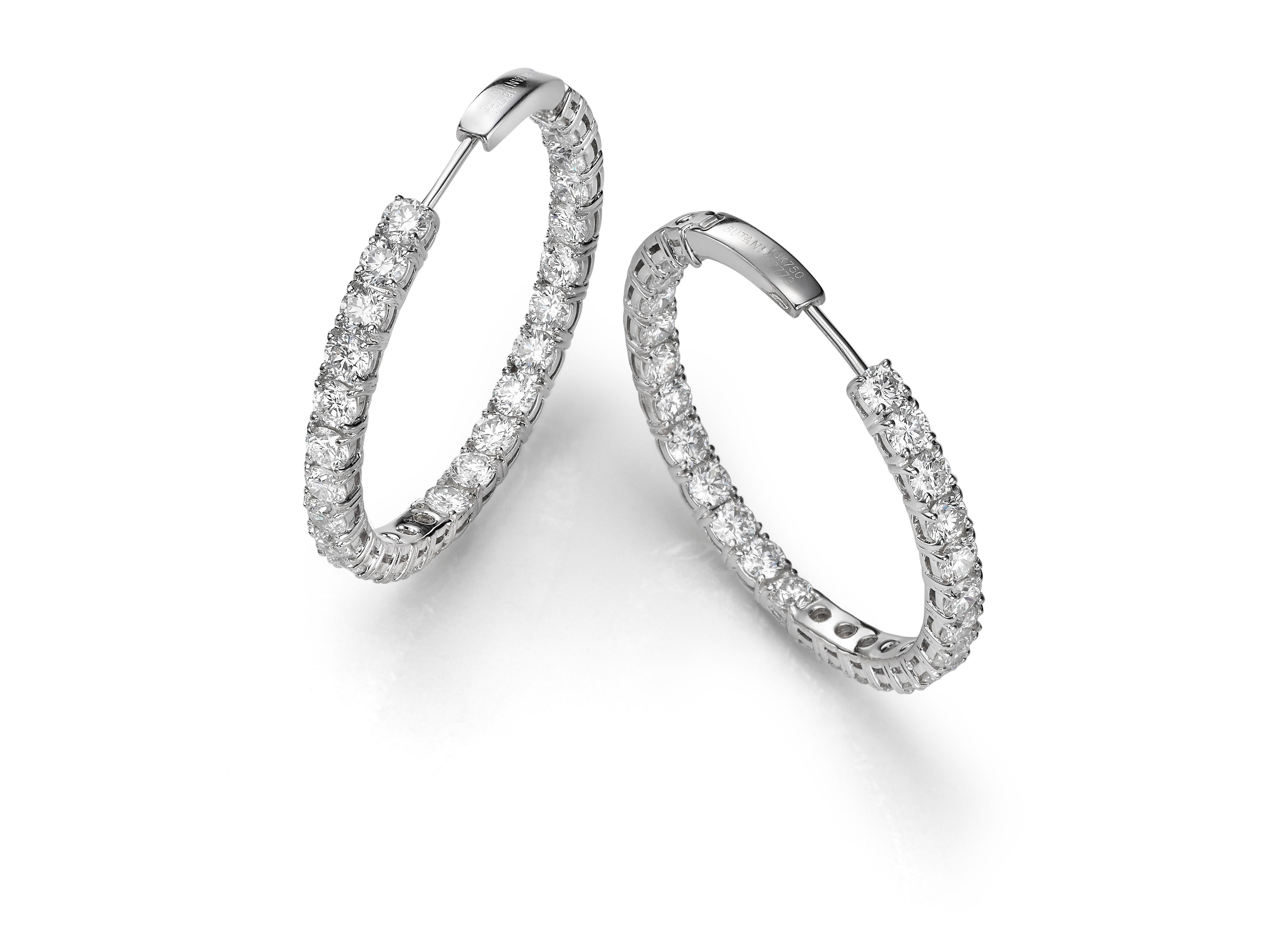 Set in 18K white gold, these classic diamond hoop earrings are encrusted with 7.24 carats of round white diamonds.  The diamonds have been carefully placed inside the curved silhouette of the earring interior to ensure they glitter from all angles. 