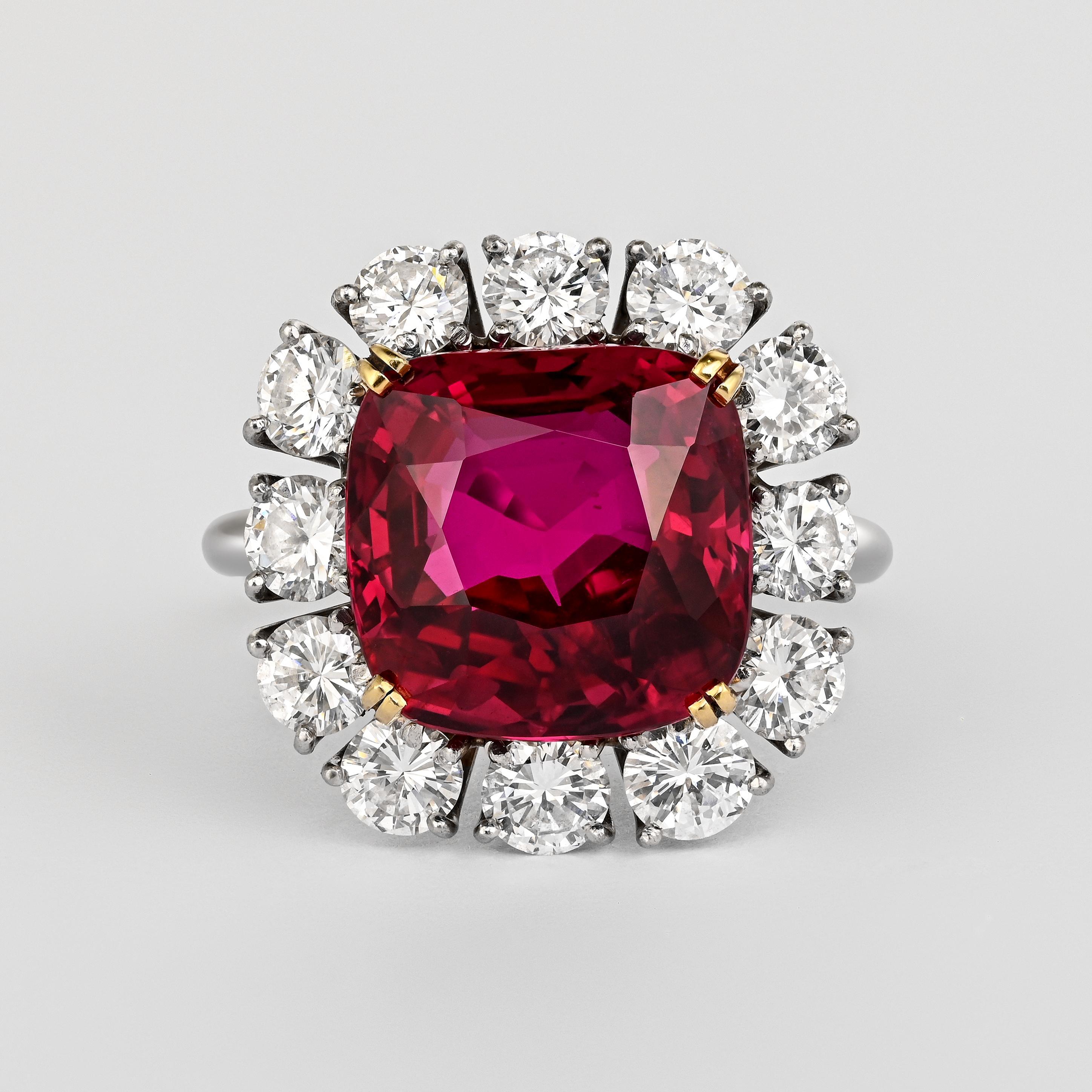 A rare and highly coveted gemstone. A 7.25 carat cushion cut ruby. GRS certified as vivid purplish red, unheated, and from Siam (Thailand). Set in 18k yellow gold and platinum with a round cut diamond halo. The ruby is slightly elongated, but set