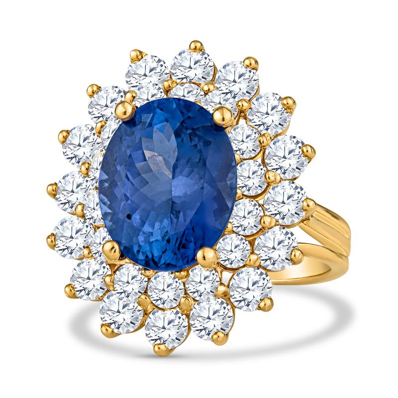 This cocktail ring features a 7.26 carat oval cut natural tanzanite accented by 4.00 carat total weight in round brilliant cut diamonds set in 18 karat yellow gold. It is a size 6.5 but can be resized upon request. 
Measurements: Tanzanite measures