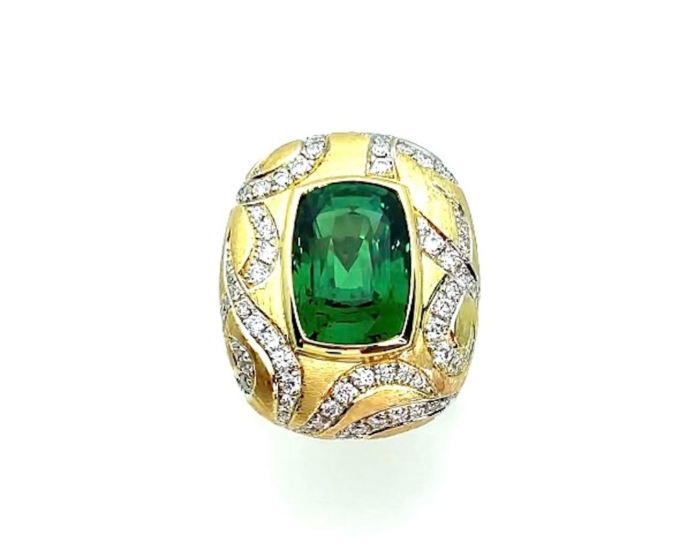 This bold ring makes a statement! The stunning 7.26 carat tsavorite garnet featured in this ring possesses a vivid, rich green color and unusually high level of clarity. Round brilliant cut diamonds set in dramatic swirls around the center bezel