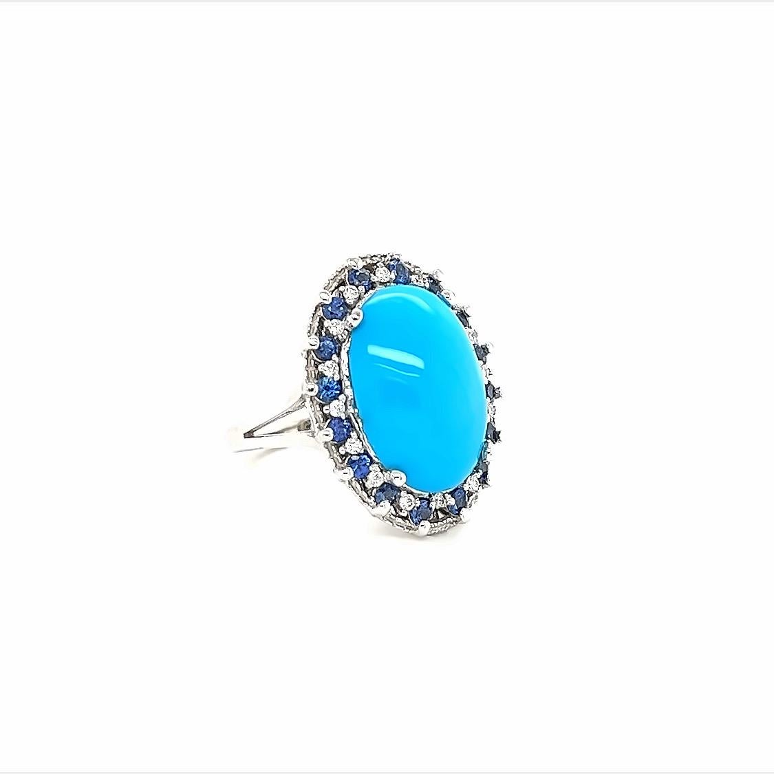 The Natural Oval Cut Turquoise is 6.48 Carats and is surrounded by a cluster of beautifully set diamonds and sapphires. There are 16 Round Cut Diamonds that weigh 0.19 Carats and 16 Round Cut Sapphires that weigh 0.79 Carats. The total carat weight