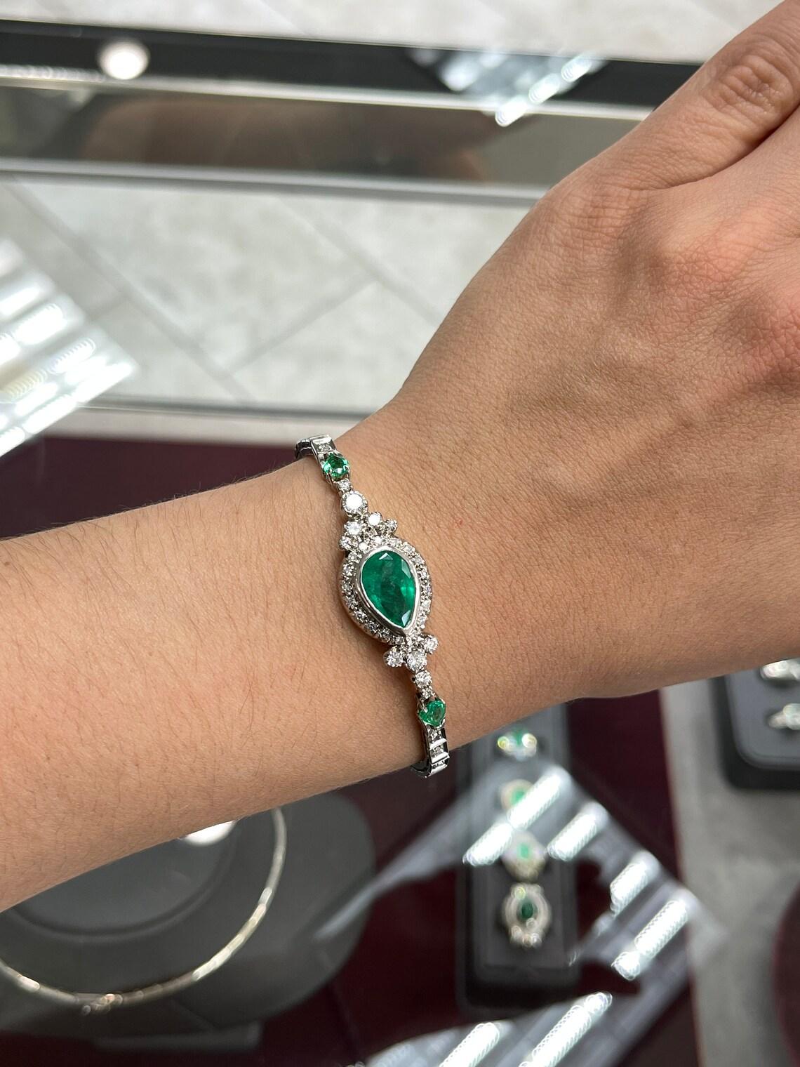 Elegantly showcased is an Art Deco bracelet with 7.27cts of radiant Colombian emeralds and diamonds. In its center, a gorgeous 5.54-carat Colombian emerald pear is bezel set in 14K white gold, a mesmerizing focal point. Lustrous emerald pears are