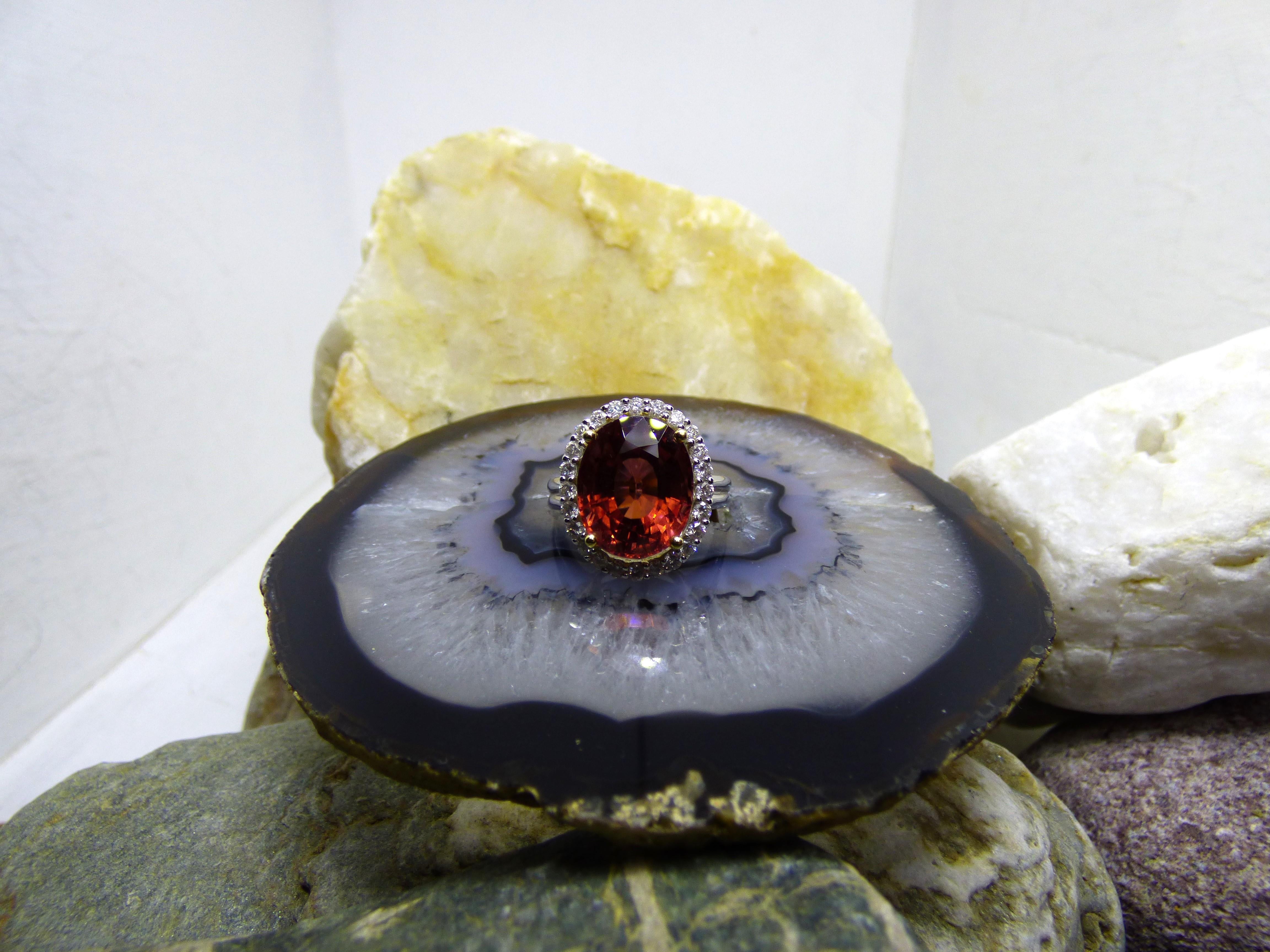 An unusual colour of Pink Tourmaline makes this ring stand out.  There are browns in this pink 7.2ct Tourmaline. The oval faceted stone is 15X9mm. It is surrounded by 24 Diamonds with a total Diamond weight of .50ct. The ring is handmade in 18K