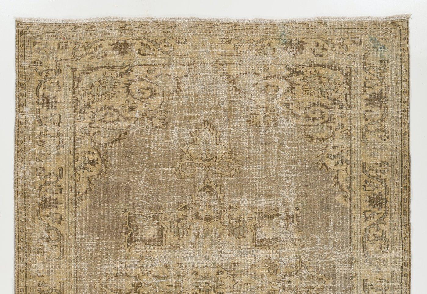 Vintage Turkish Oushak area rug, hand-knotted in Turkey in the 1960s with low wool pile on cotton foundation. It features a large medallion at its center and arabesque corner pieces in soft, muted hues of taupe gray, sand and moss green. The rug is