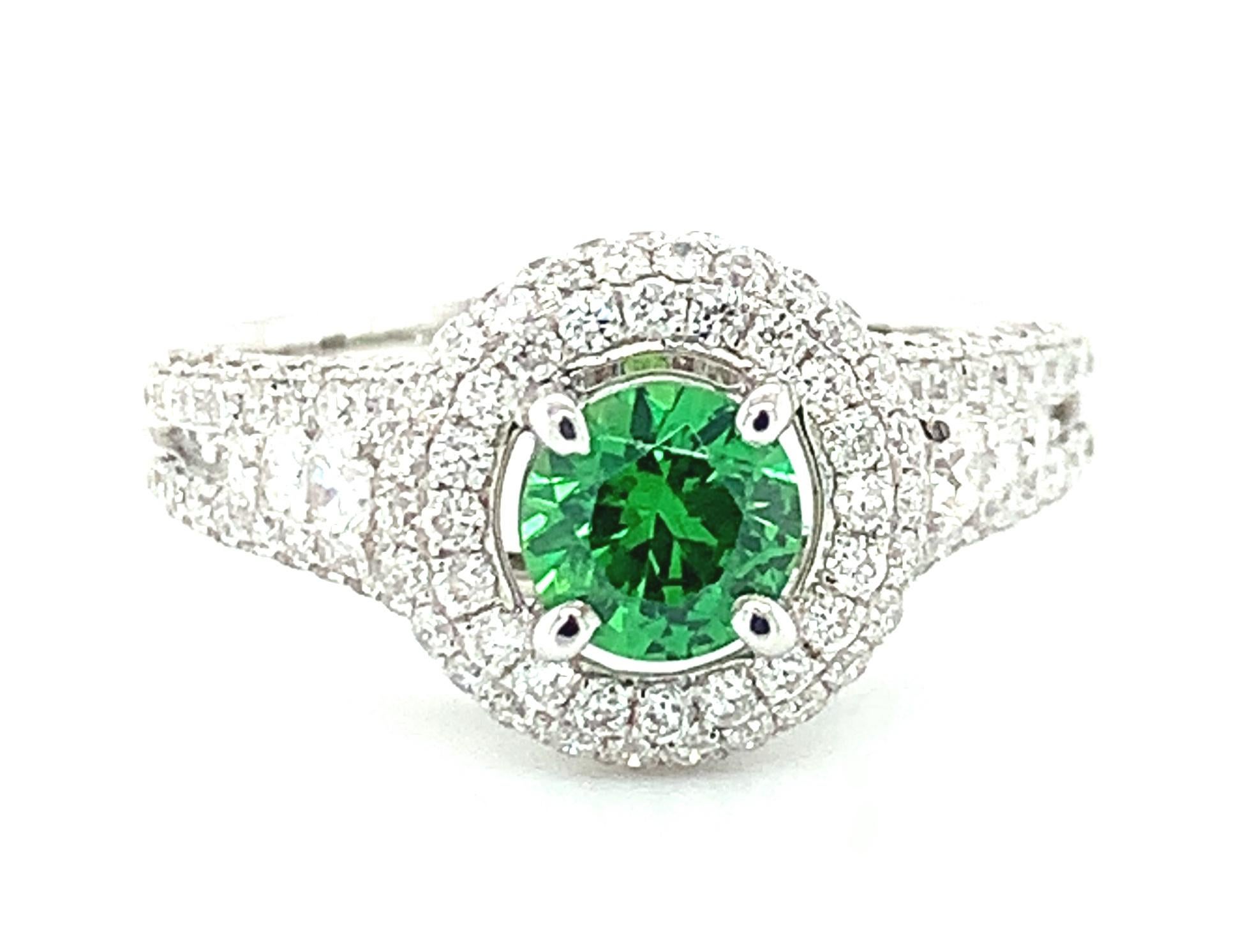 Brilliant and bright, this tsavorite garnet and diamond ring is dazzling! A beautiful, round, vibrant green tsavorite garnet is framed by not one or two, but three rows of sparkling white diamonds that weigh over a carat total! 
The center stone is